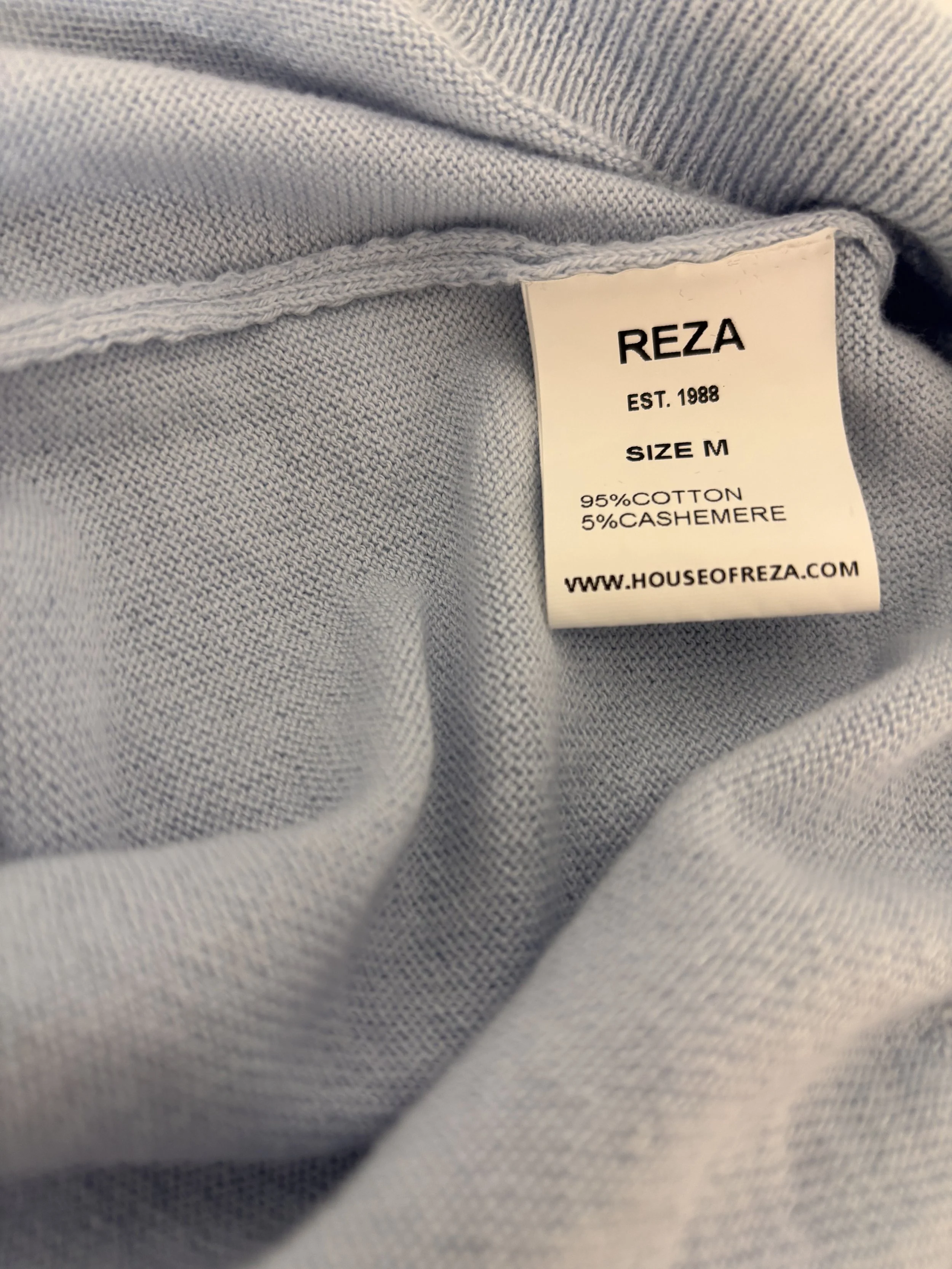 REZA sky blue cotton cashmere blend knit fabric detail with composition label and fine knit texture