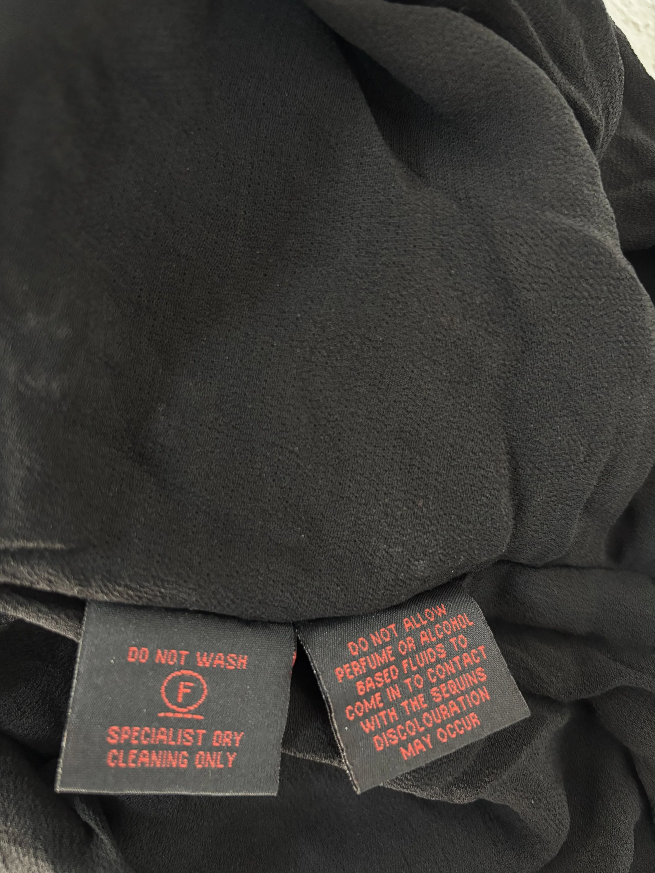 Frank Usher specialist dry clean care label on black silk top