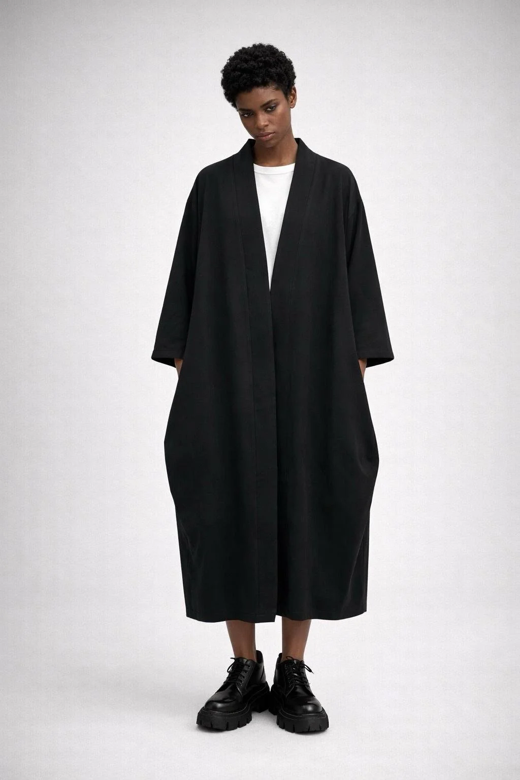 Black kimono-style cardigan worn on model, relaxed oversized silhouette, minimalist Italian design