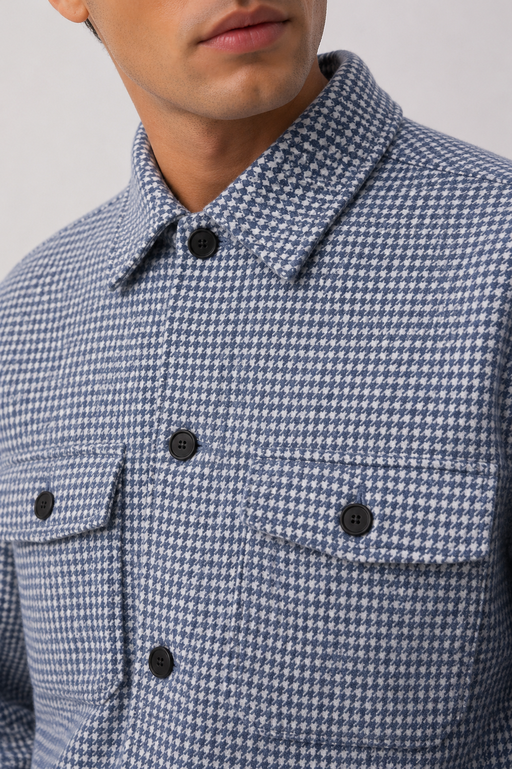 Close-up detail of Reiss blue and ivory houndstooth overshirt featuring premium wool blend fabric, structured collar and button fastening.