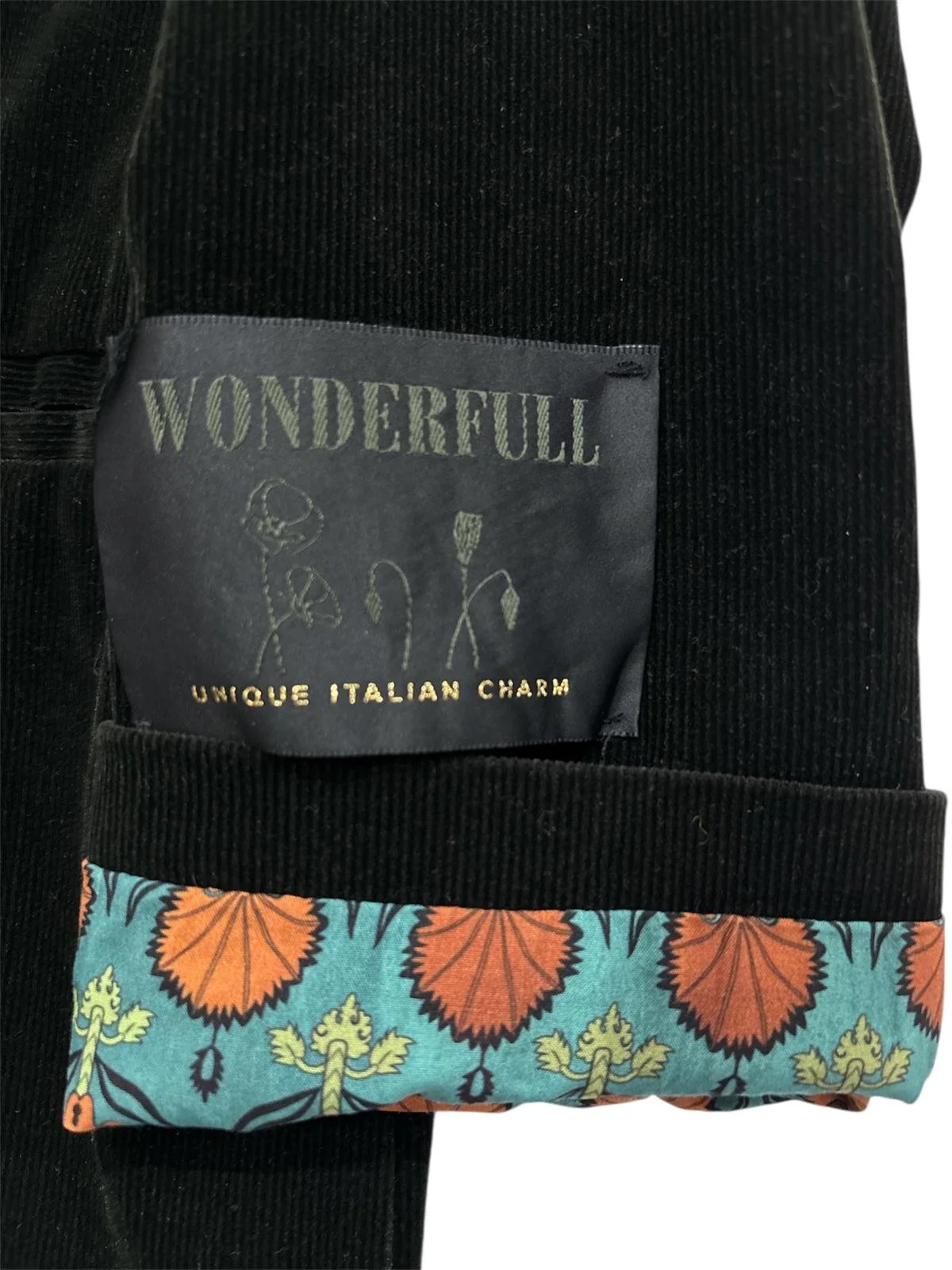 Black velvet blazer sleeve with floral lining and label