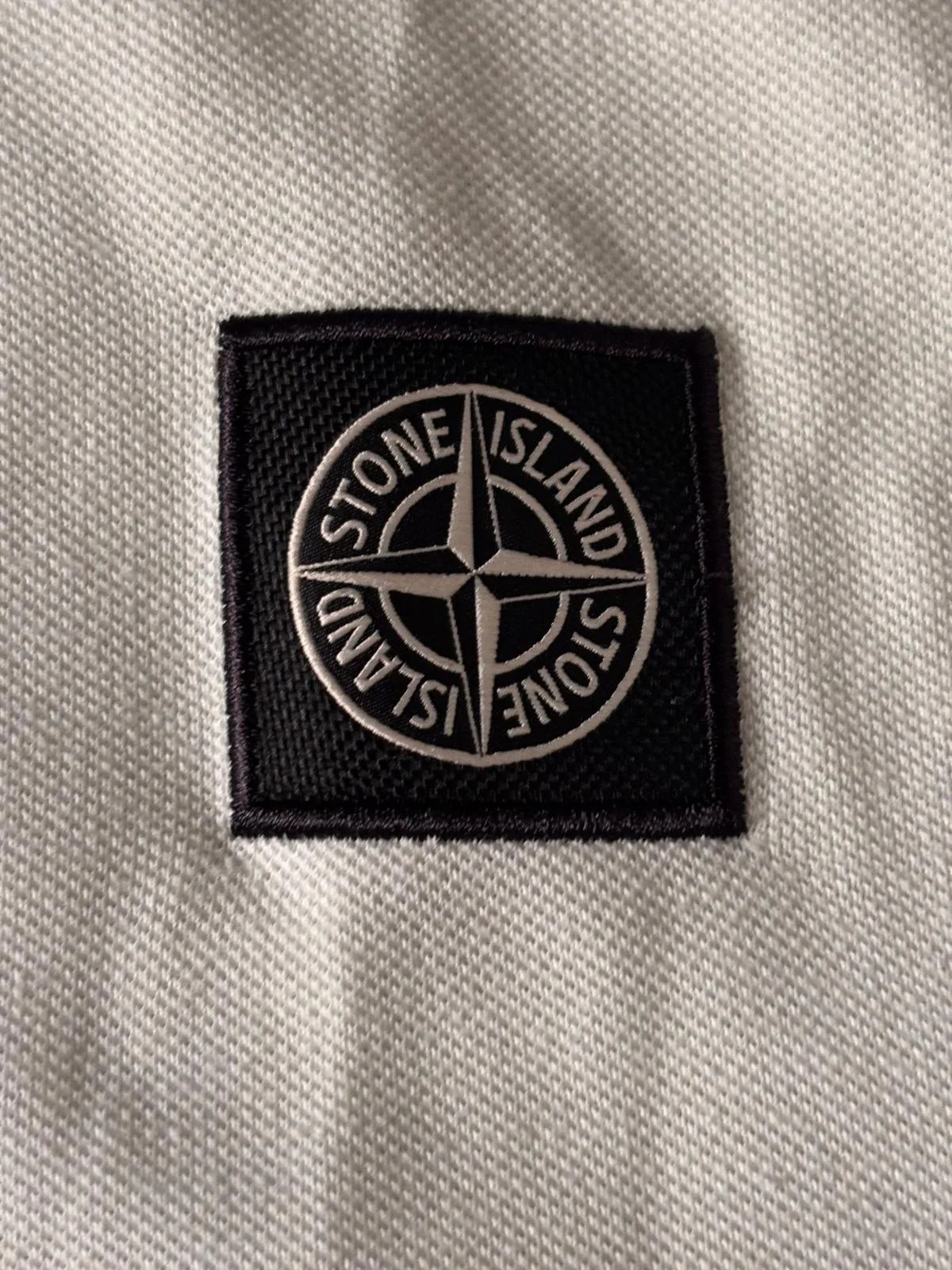 Stone Island compass logo patch detail on polo shirt