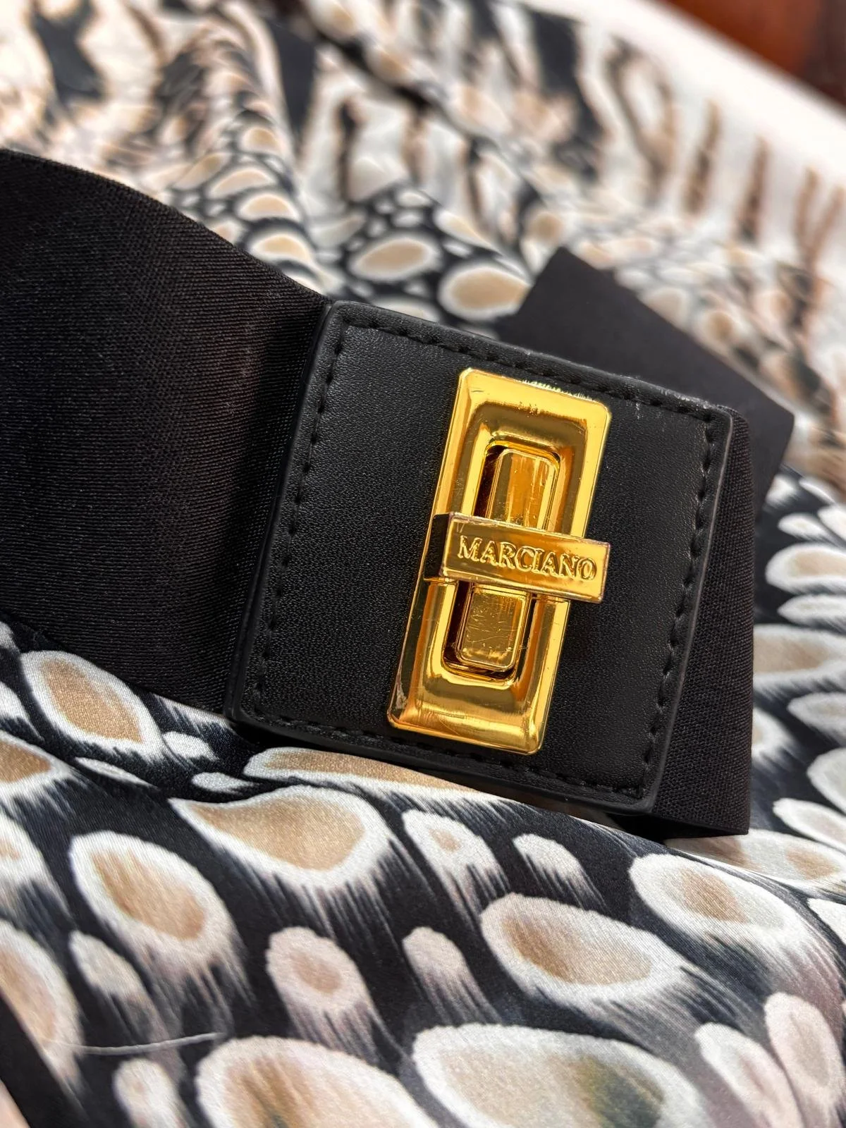 Merciano by Guess gold logo belt buckle close up detail