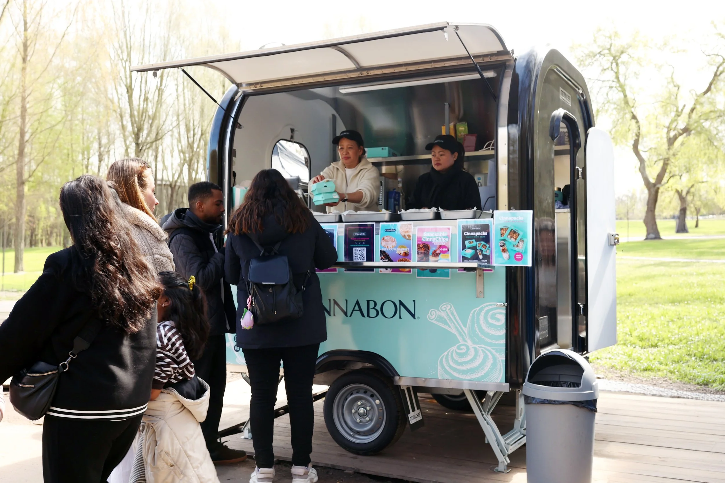 Cinnabon foodtruck in Bloesempark tijdens kersenbloesem seizoen in Amsterdamse Bos, met cinnamon rolls en milk tea tijdens Pasen