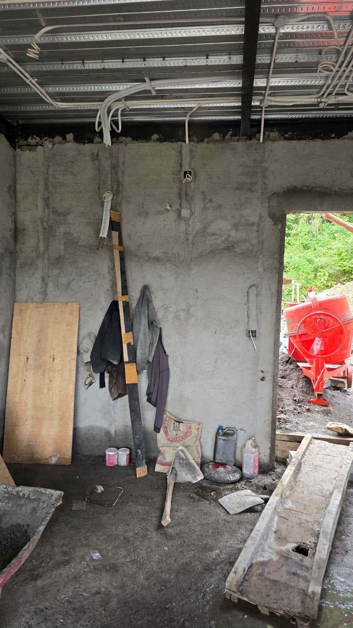 Interior of a construction site with unfinished walls and exposed wiring, construction tools and supplies.