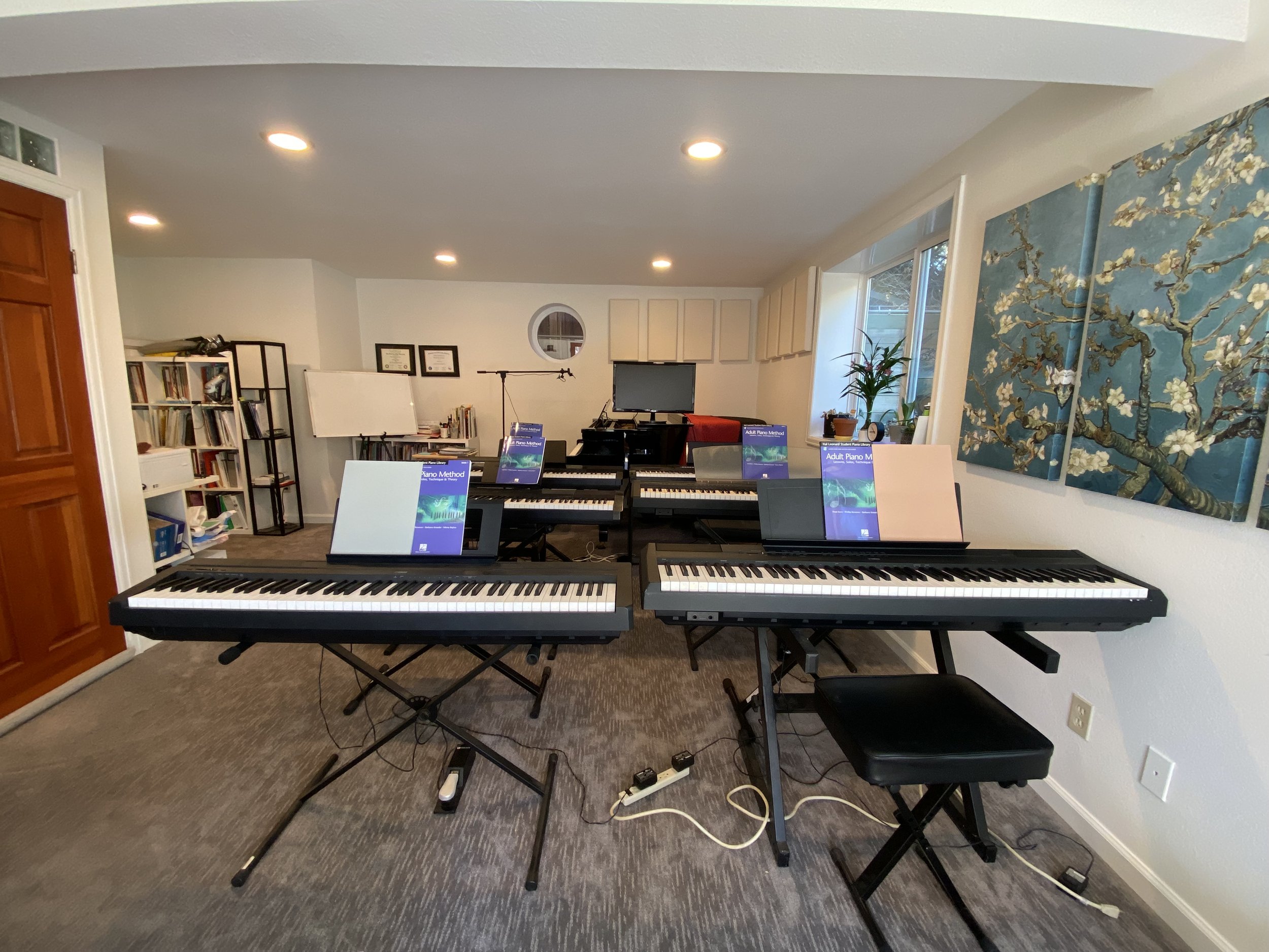 6 keyboards lined up in a piano studio