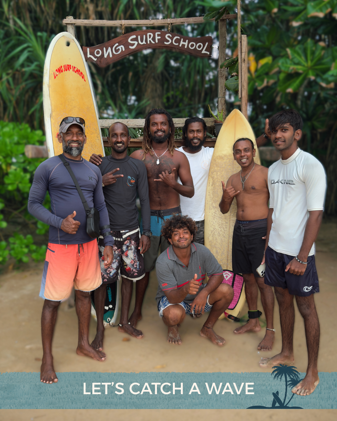 Group of seven men standing on the beach with surfboards and a wooden sign that reads 'Long Surf School', surrounded by lush green foliage, with the caption 'Let's Catch a Wave' at the bottom.