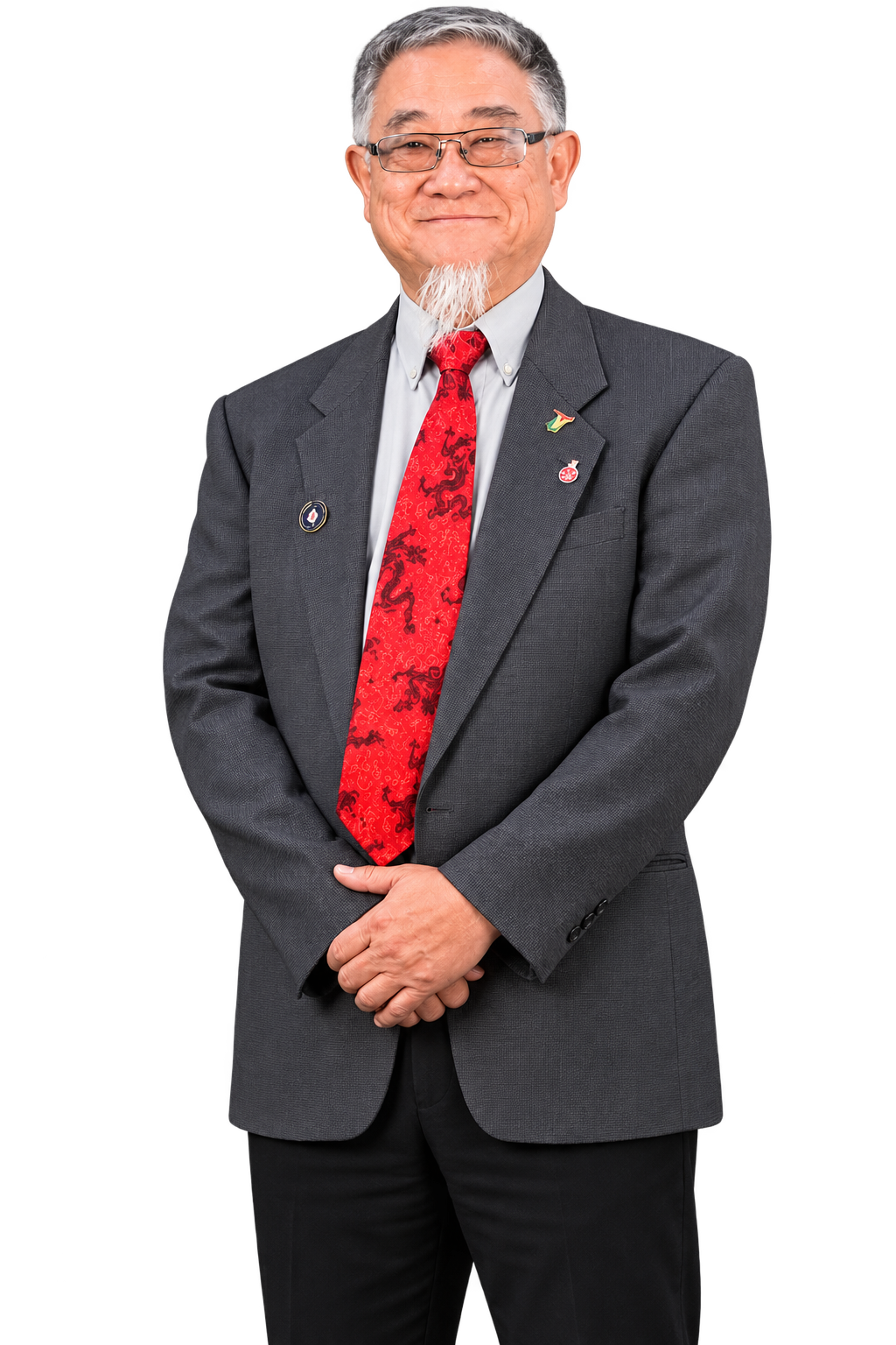 A smiling man in a gray suit, red patterned tie, and glasses.