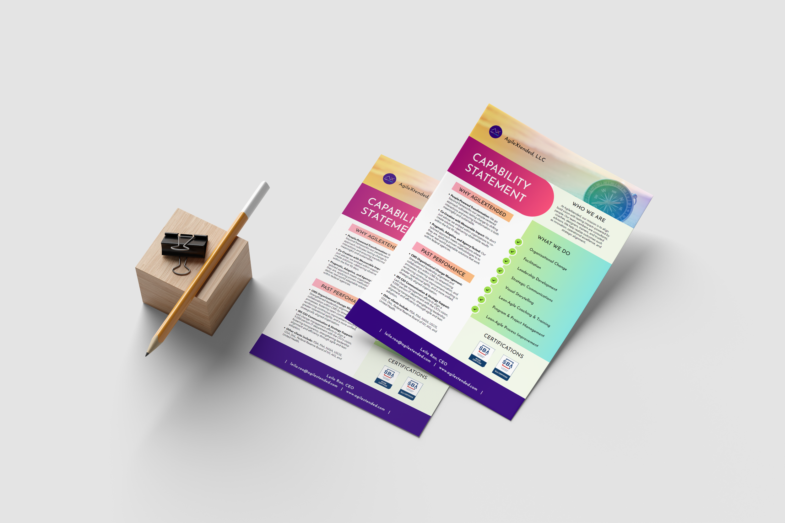 Two printed flyers about AgileExtended LLC's capability statement, placed on a white surface with a wooden block, binder clip, and pen.