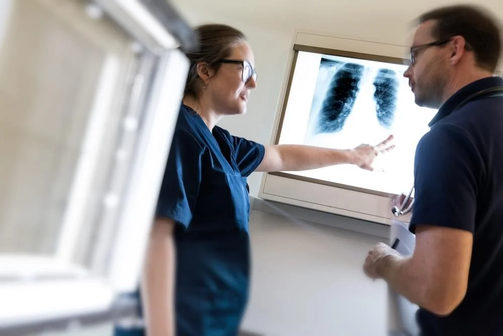 Medizinerinnen besprechen Röntgenbild der Lunge im Behandlungszimmer.