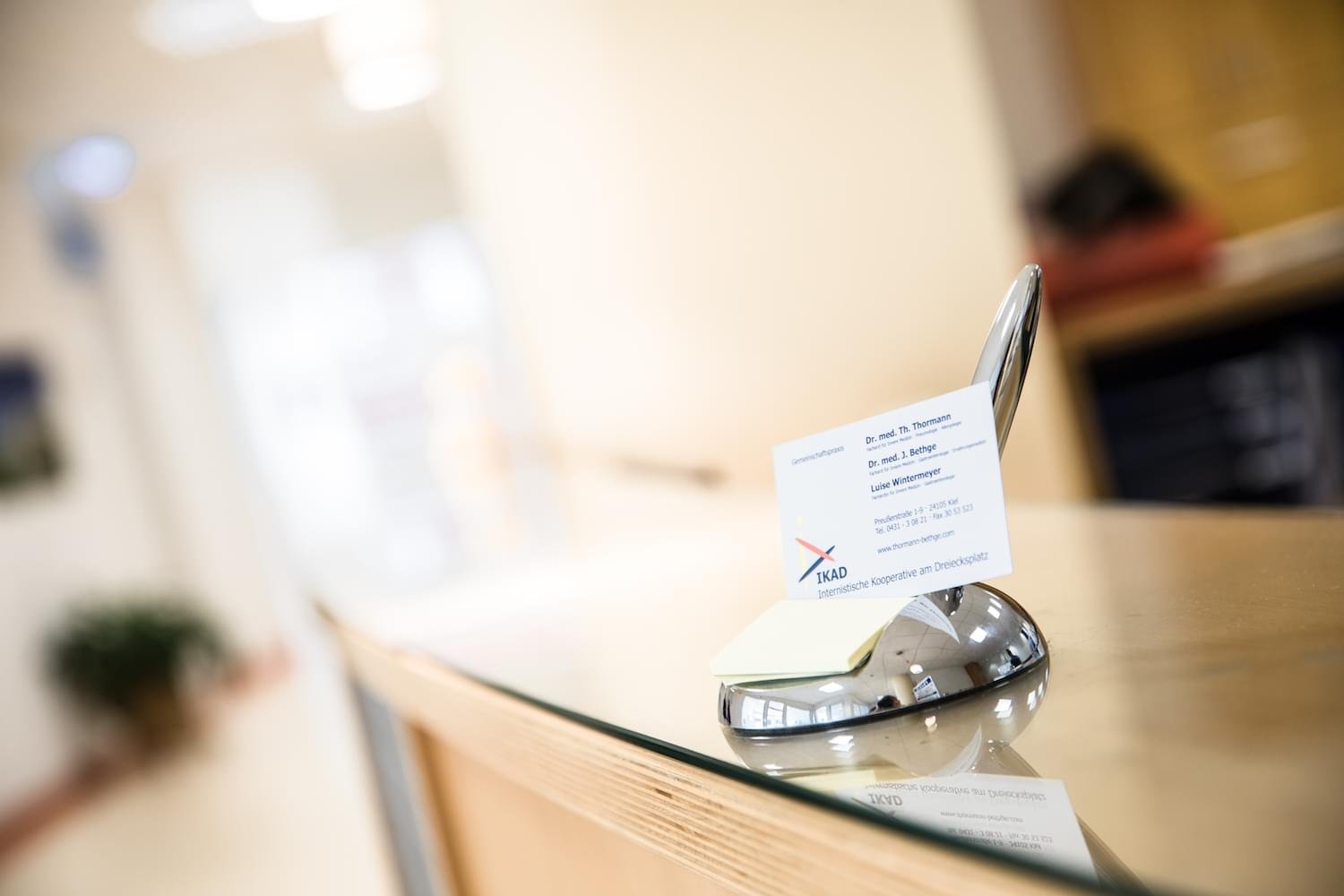 Visitenkarte auf einem silbernen Stand auf einem Empfangstresen