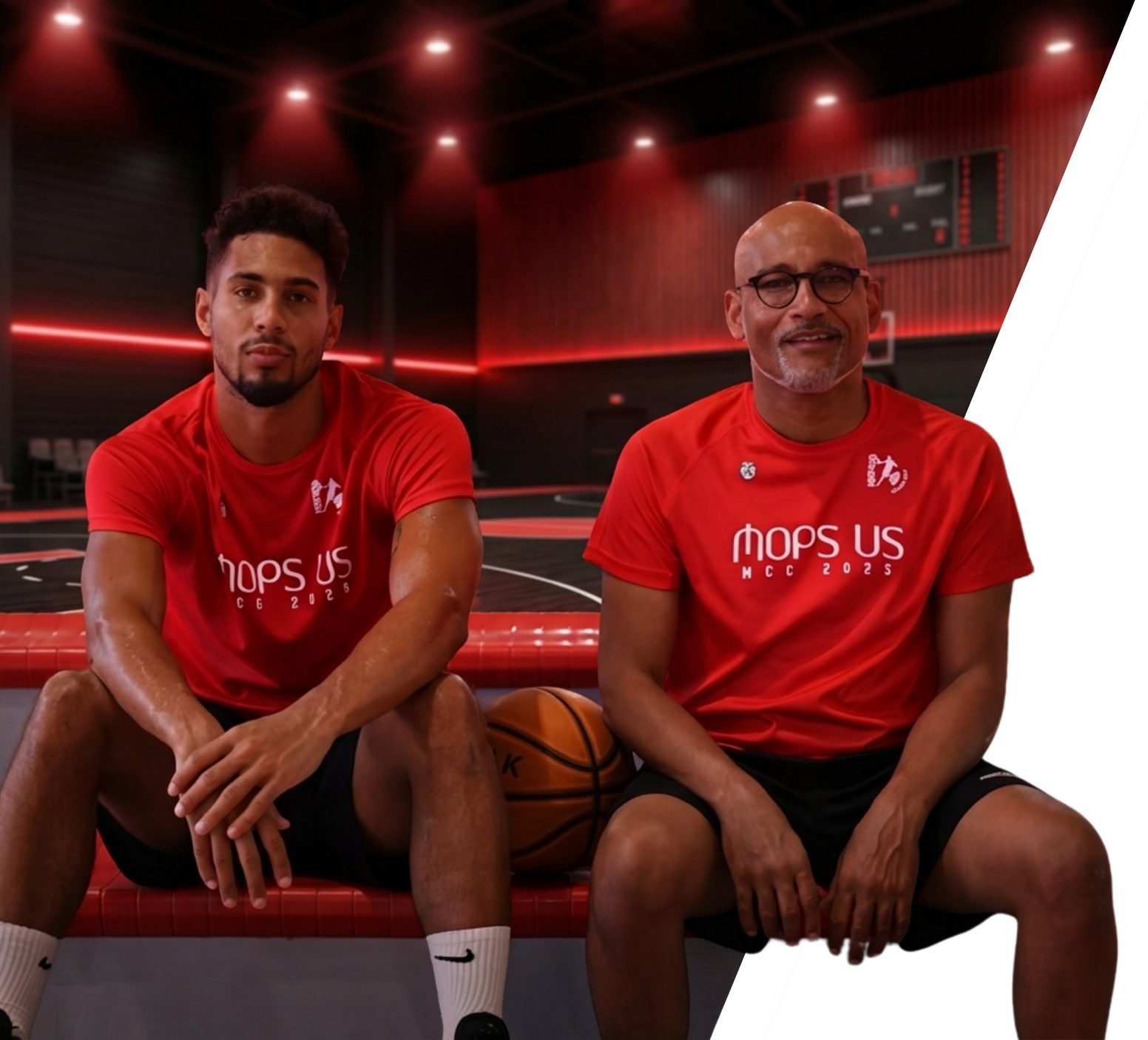Deux hommes assis sur un banc de basketball dans une salle de sport avec un parquet noir et des murs en bois, portant des t-shirts rouges avec le texte 'mops US' et 'MCC 2022', un ballon de basket entre eux, ambiance lumineuse rouge et noire.