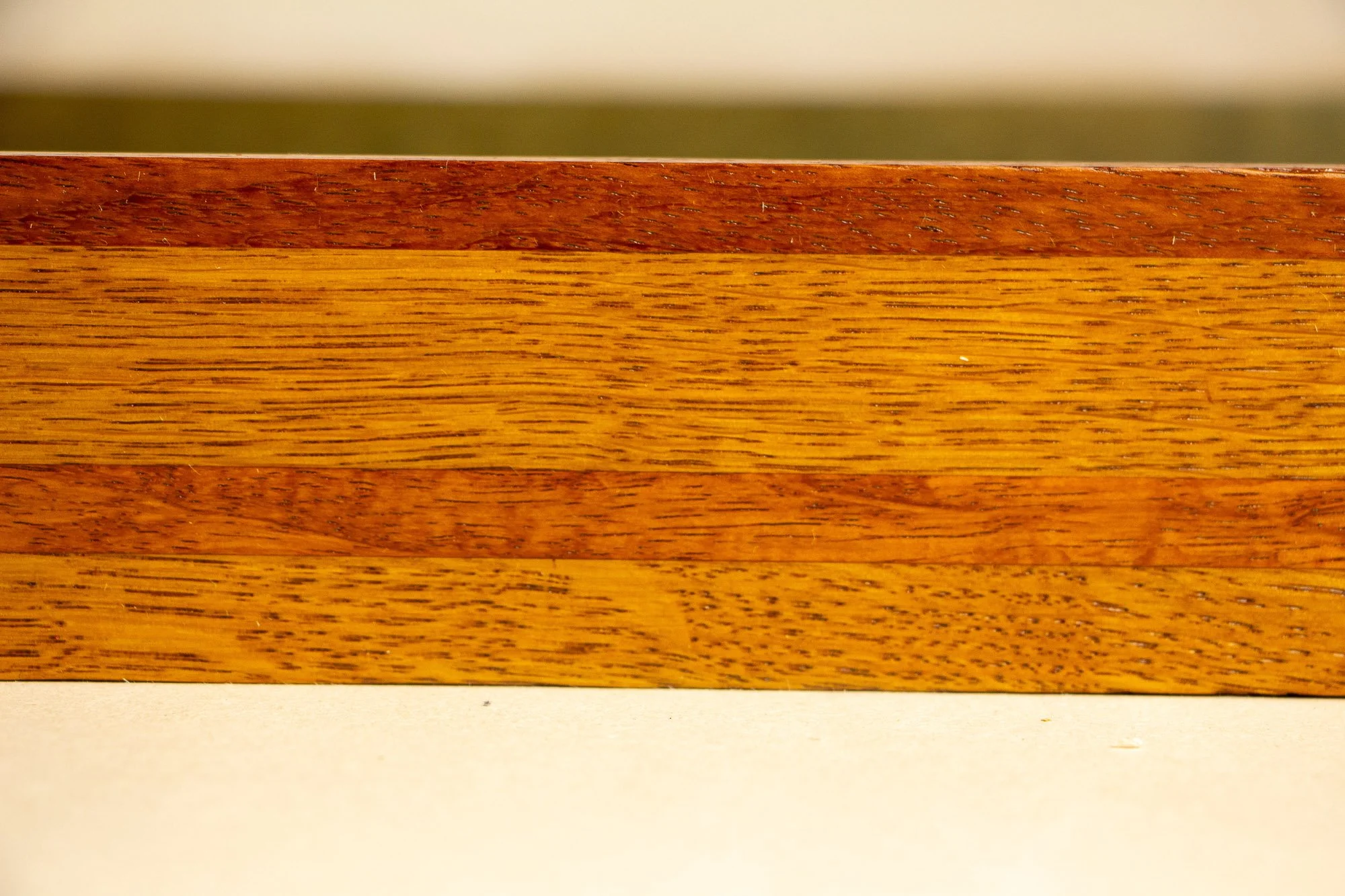 Unseen Signifiers 006 frame detail: straight-on close-up of the frame side, highlighting the horizontal striped wood composition in alternating reddish-brown and golden tones. mahogany, oak and beech wood.