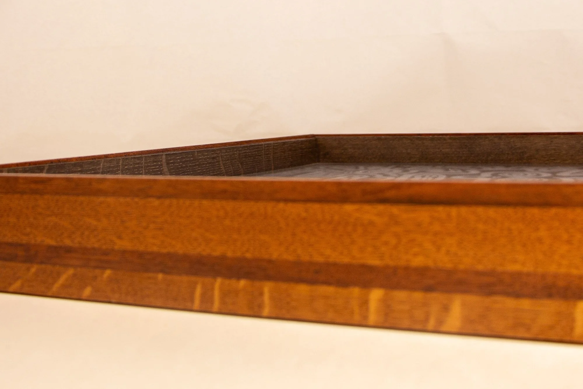 Turbulent Aegis 002 frame detail: oblique side close-up of the frame profile, emphasizing the elongated grain pattern, glossy handcrafted finish, and the warm-to-dark tonal transition within the layered construction.