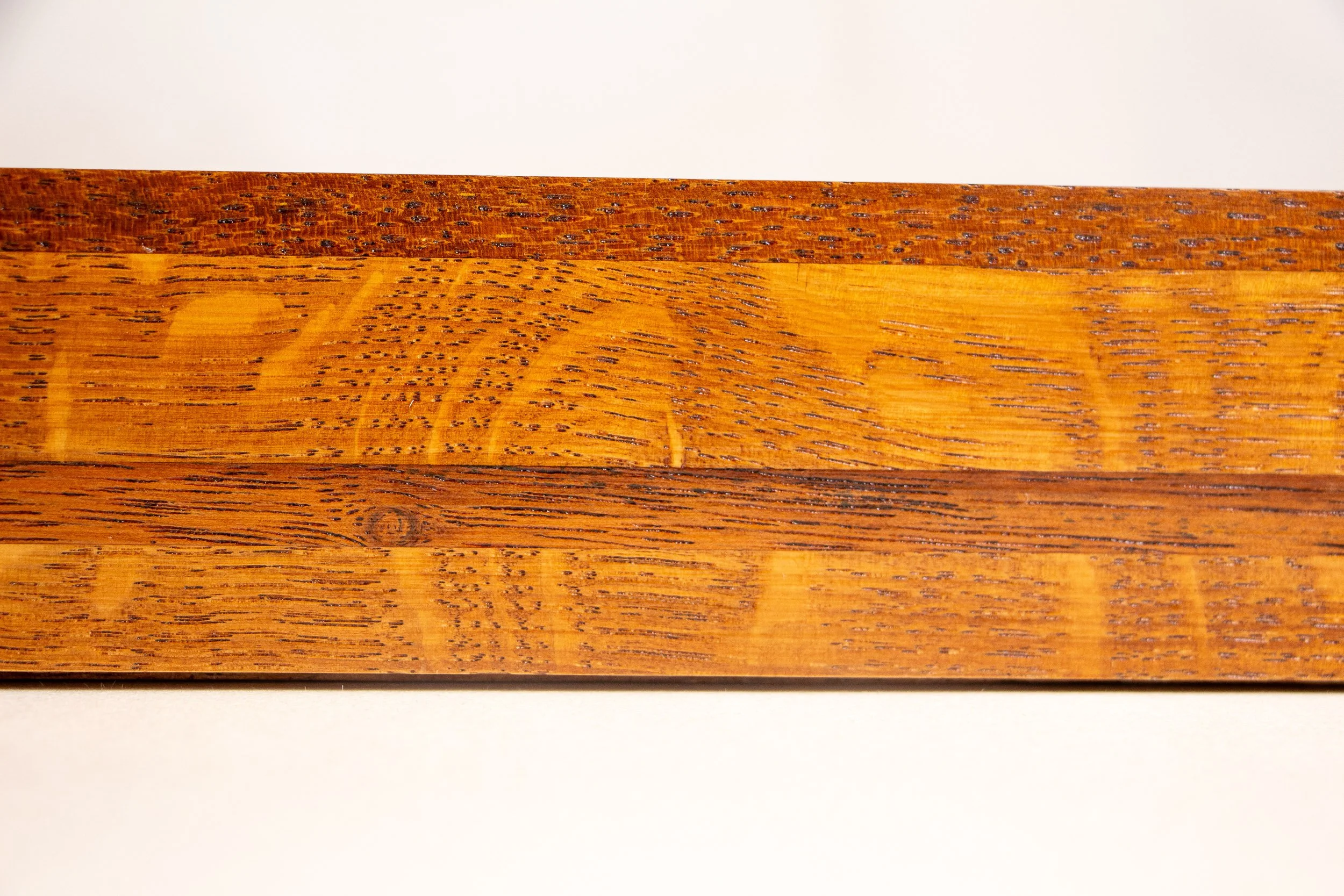 Turbulent Aegis 003 frame detail: frontal side close-up of the frame profile, highlighting the horizontal wood layering, tonal variation, and the refined handcrafted finish across the full band.