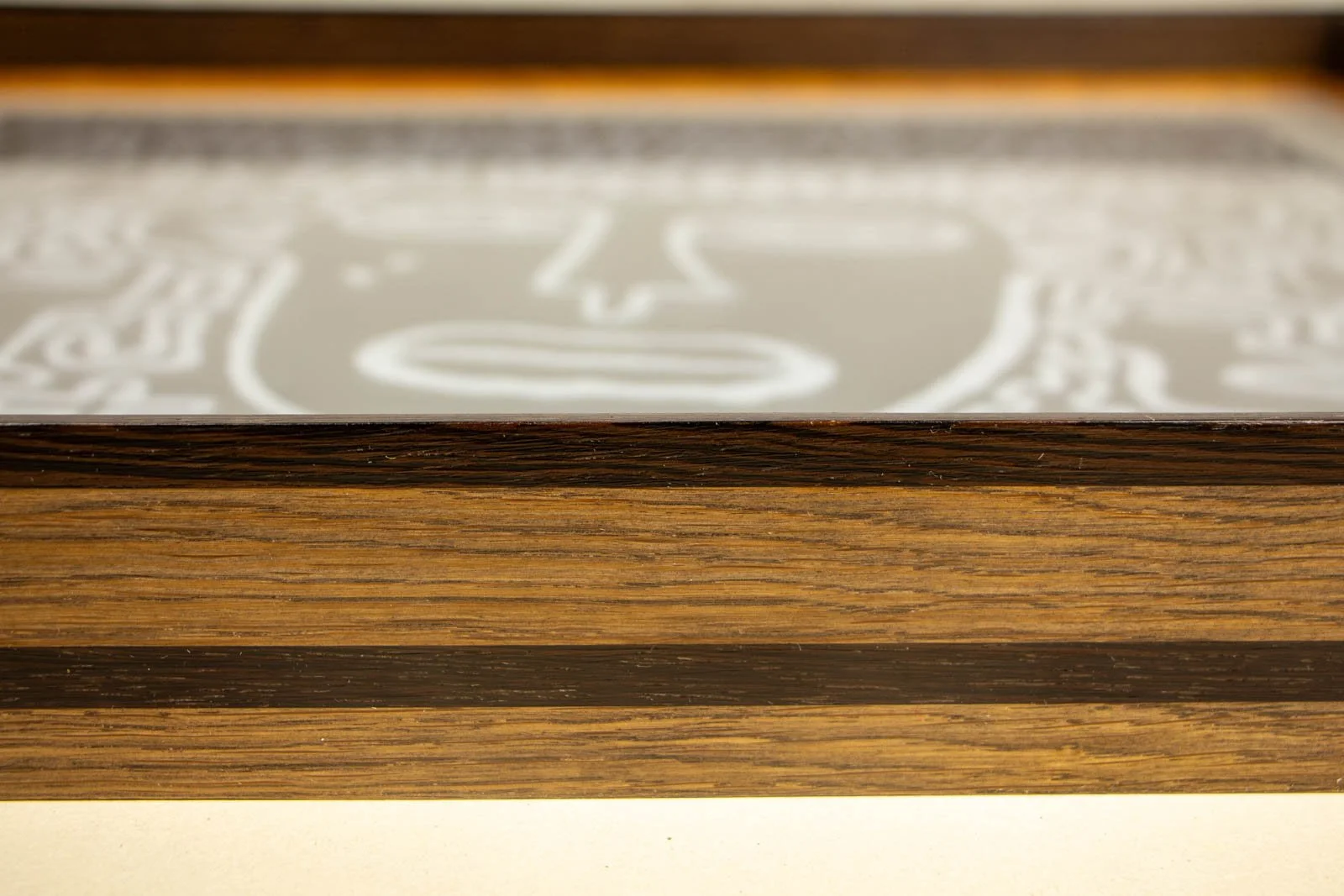 Synaptic Mythos 001 frame: ash-stained oak with a slim wengé cap and a continuous wengé mid-band; glass set flush above the grain