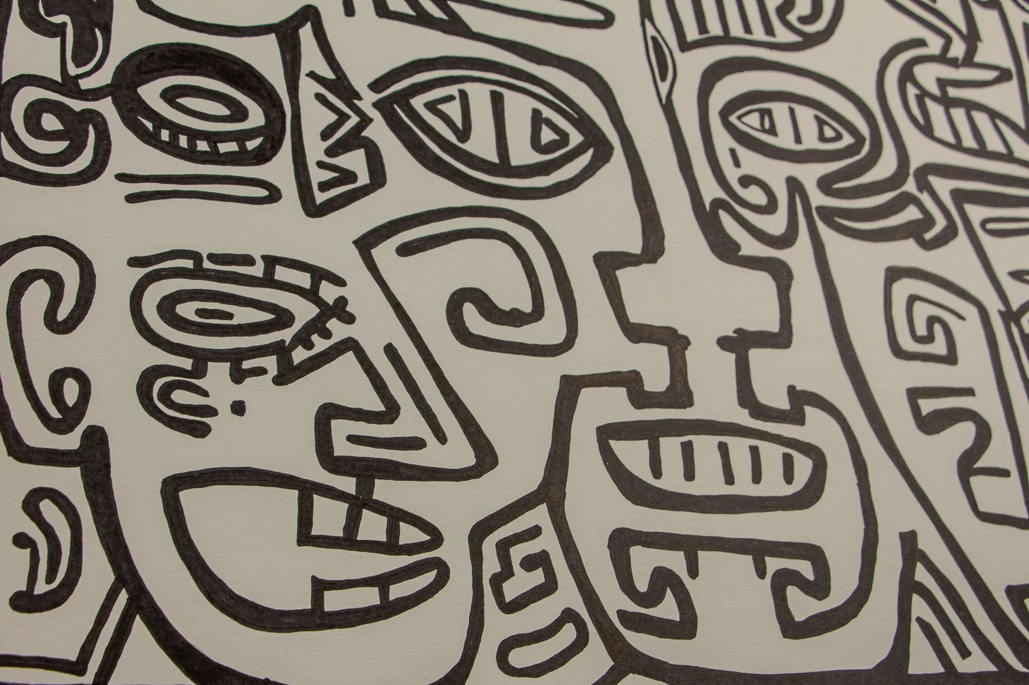 Elusive Cocoon 004 detail: close-up of two adjoining face-like forms with almond eyes, spiral and stepped contours, and geometric mouths, rendered in bold black linework on warm white paper.
