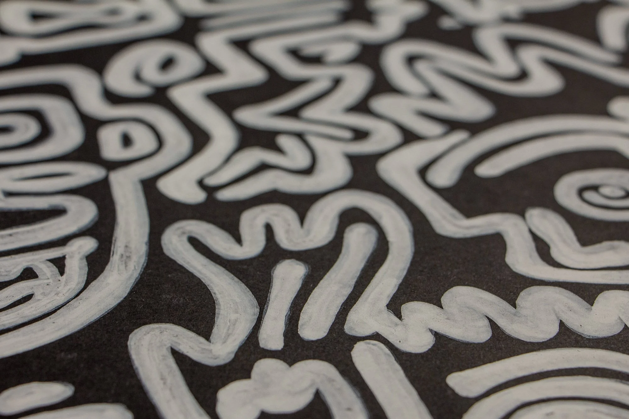 Turbulent Aegis 001 artwork detail: shallow-focus close-up of white line work on a dark ground, showing a heart-like motif and surrounding abstract forms that drift between tenderness and unrest.