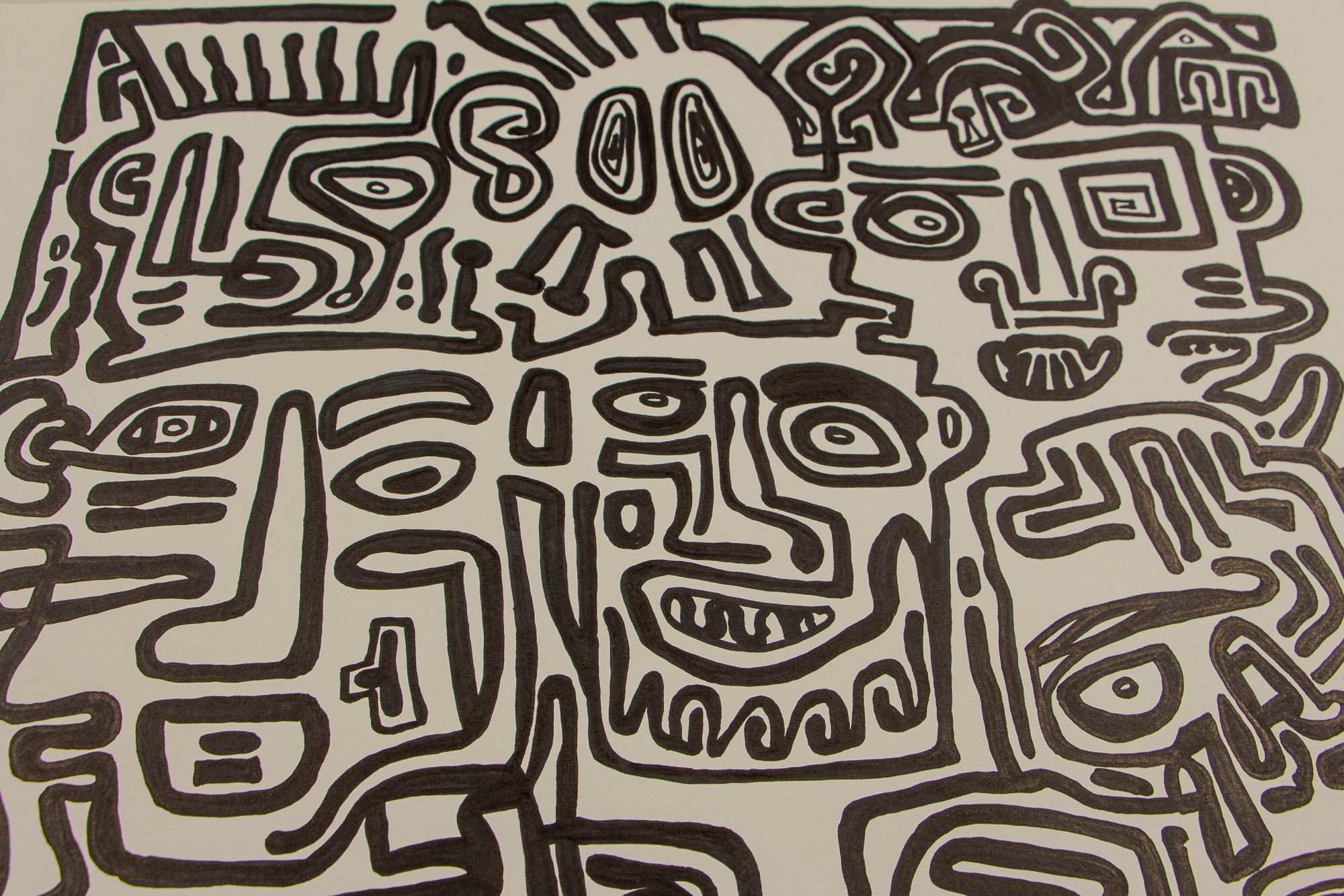 Veiled Alchemist 004 detail: close-up of the composition centered on a bearded face with asymmetrical eyes and a tooth-like grin, surrounded by tightly interwoven abstract figures and symbolic black contours on white paper.