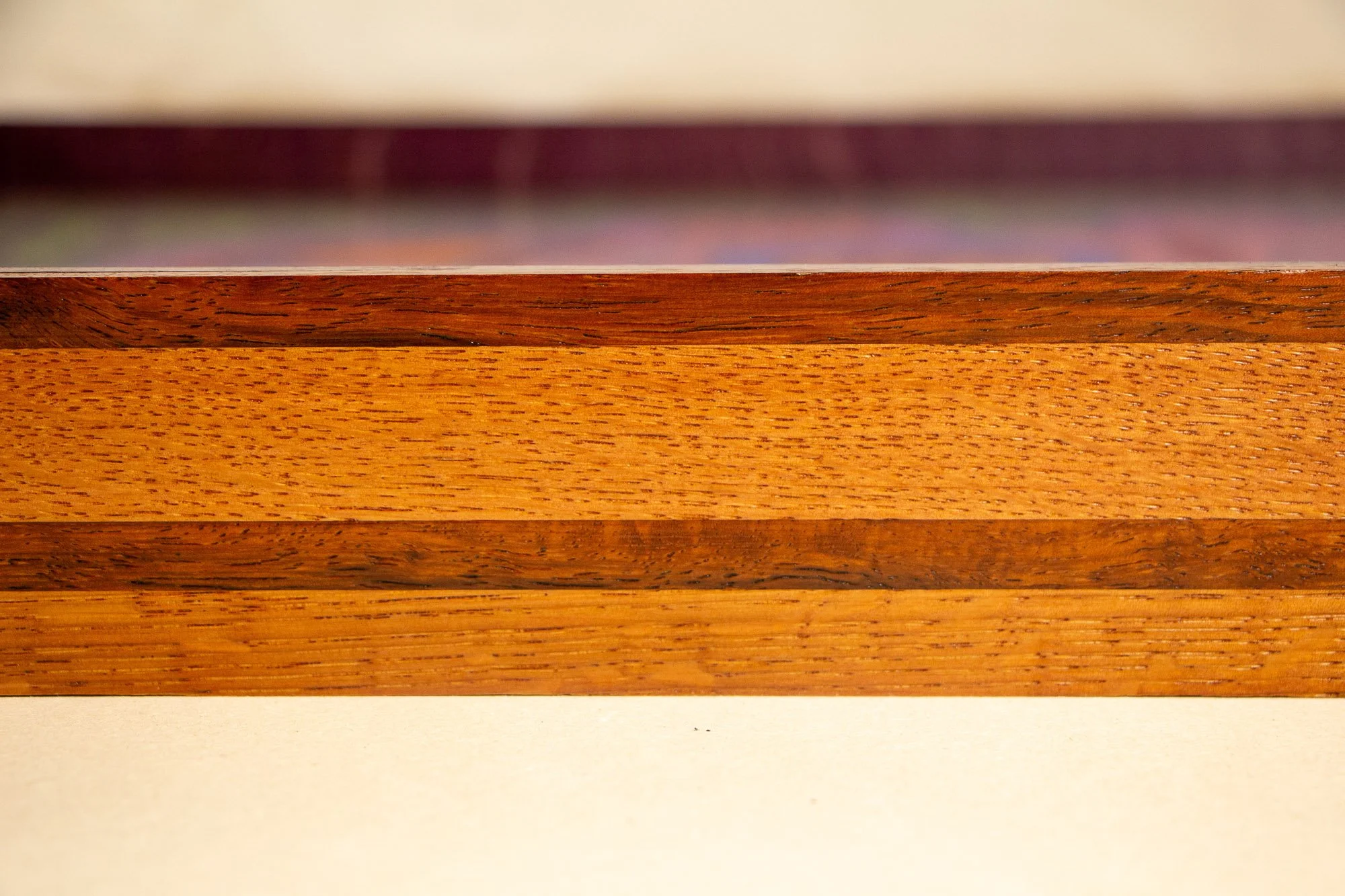 Unseen Signifiers 005 frame detail: horizontal close-up of the frame profile, focusing on the contrast between the dark top rail, the lighter oak band beneath it, and the darker inlay line running across the centre. mahogany, oak and beech wood.