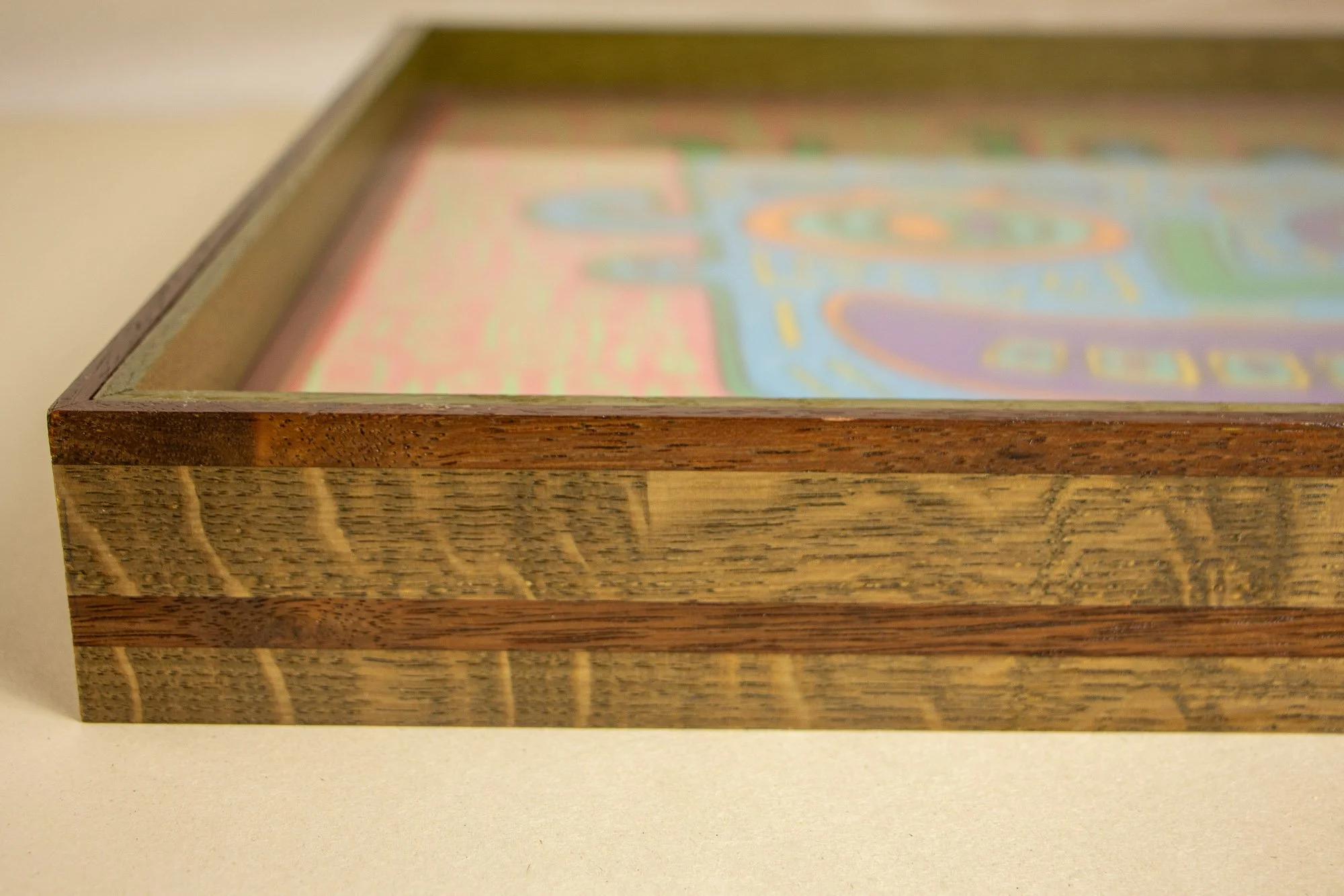 Close-up of a wooden display case with a colorful, abstract picture inside.