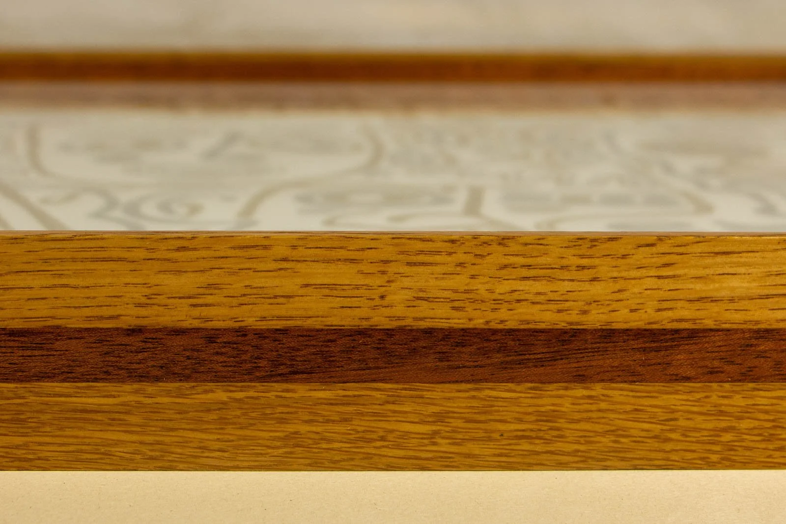 Golden Nostalgia 002 frame: low side profile, broad oak face; warm mahogany stripe runs true across the length