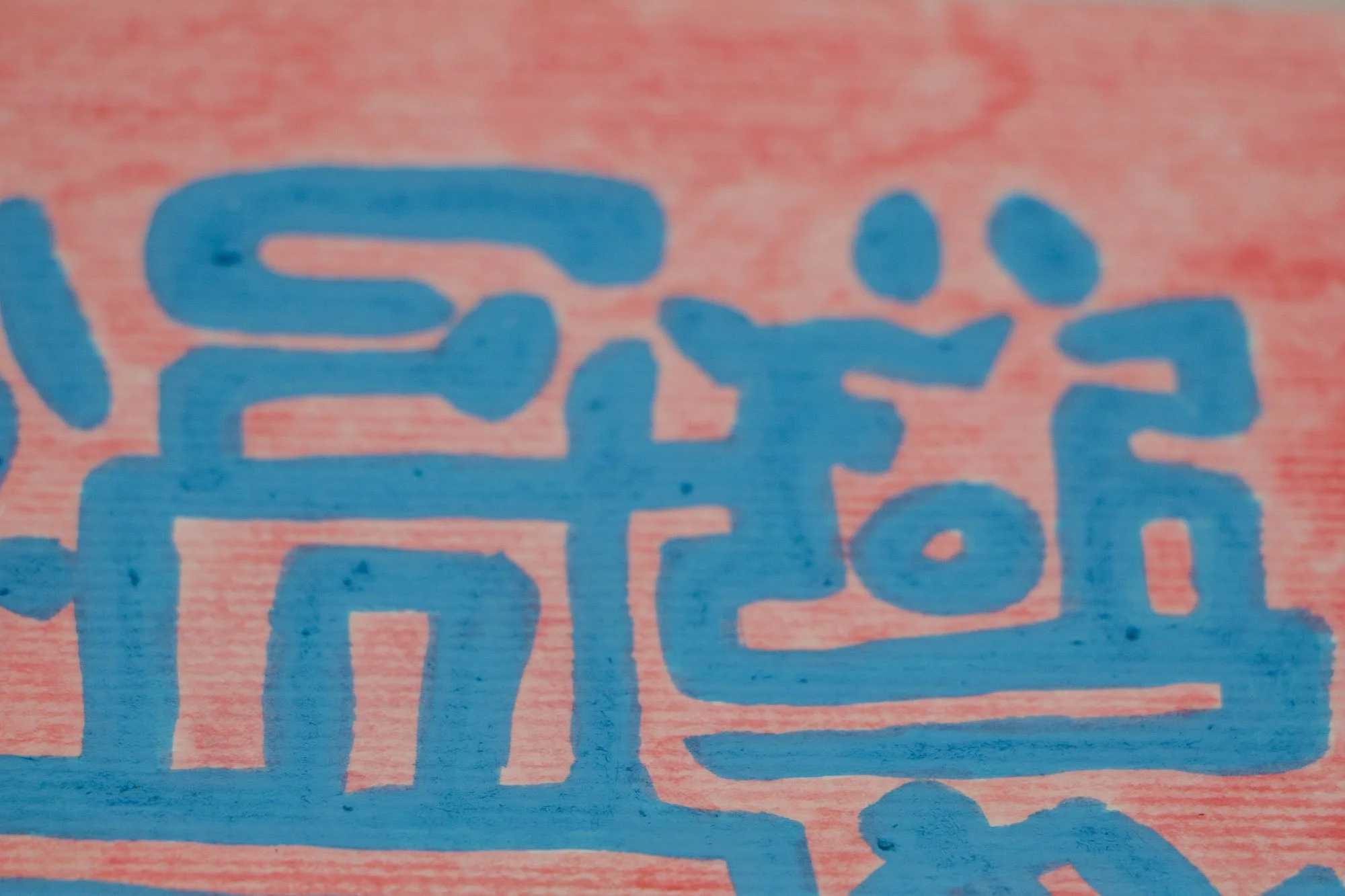 Unseen Signifiers 006 detail: close-up of the right-side pink field, focusing on a light-blue face-like glyph and surrounding curving symbolic lines near the edge of the head.