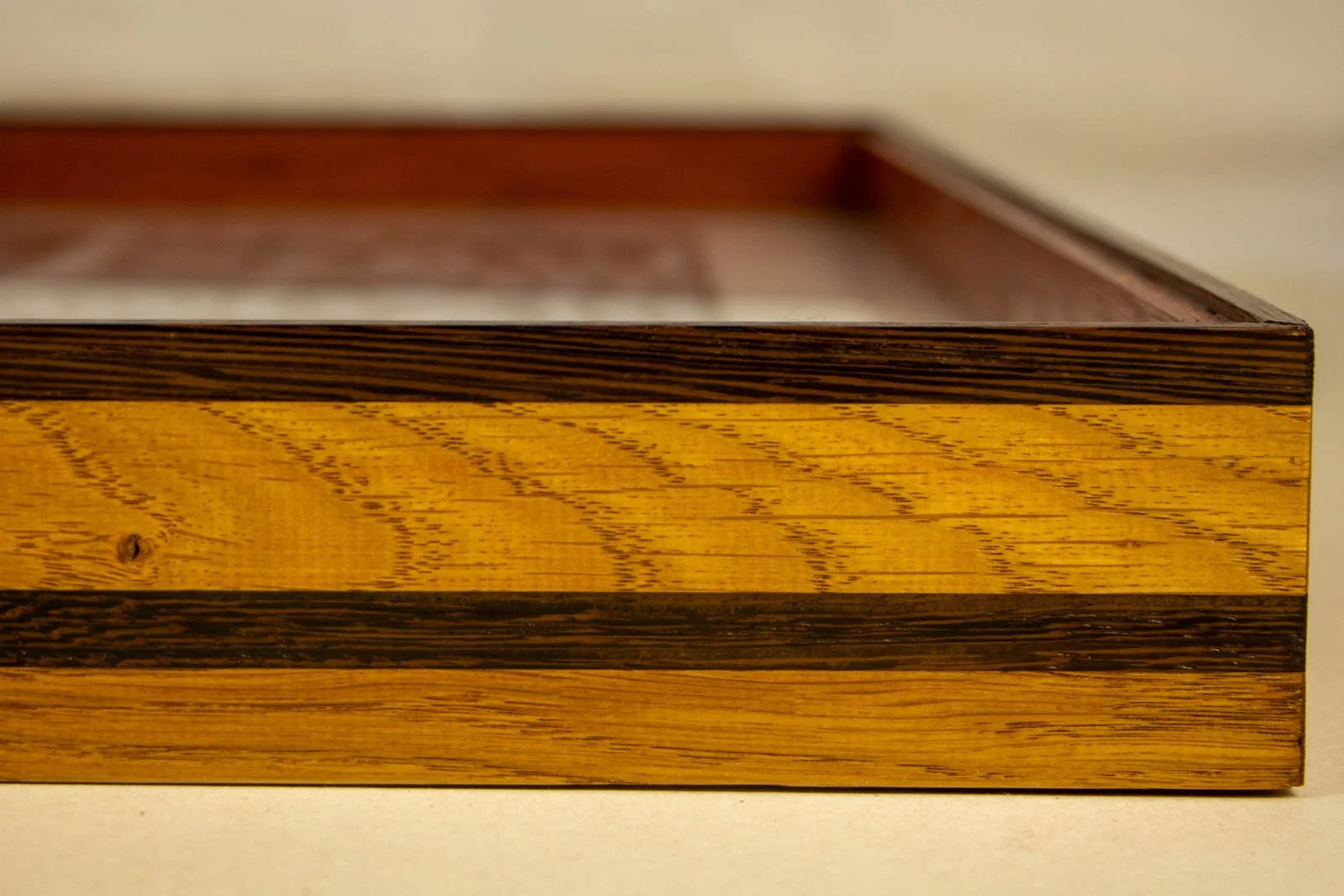 Metamorphic Entwining 002 frame: oak frame with slim wengé cap and a continuous wengé band; honey-gold grain; glass set flush