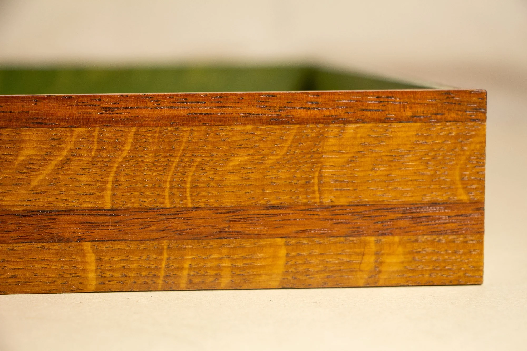 Unseen Signifiers 002 frame detail: end view of the frame with the glass edge visible above the layered wooden profile and its contrasting darker central band. mahogany, oak and beech wood.