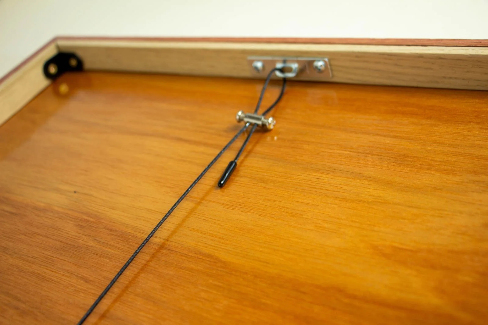 Silence’s Caesura 001 frame: hanging system, gallery wire with brass barrel tensioner fixed to a slotted plate; beech inner rail and corner brace over a honey-varnished backboard