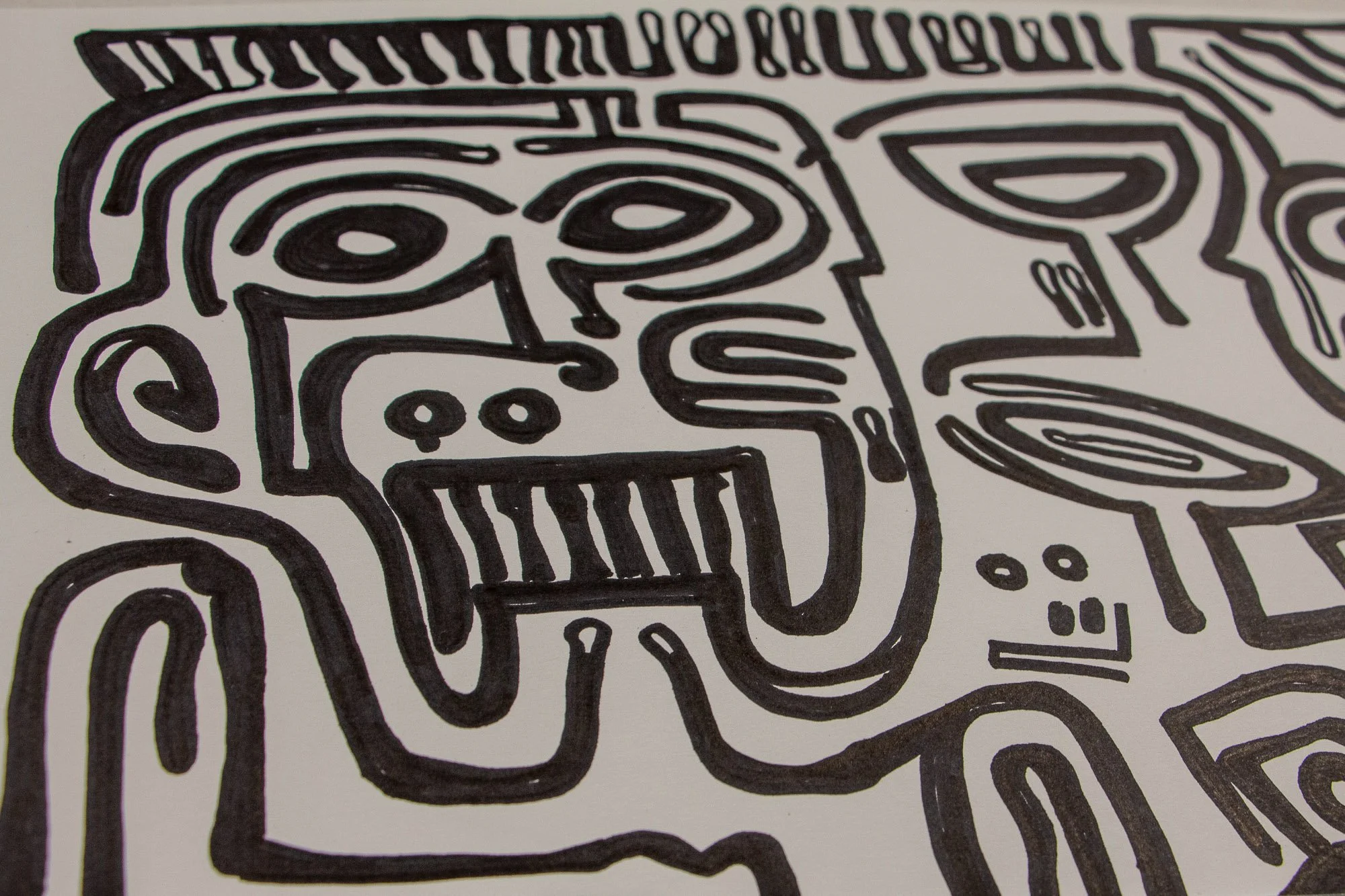 Veiled Alchemist 001 detail: close-up of an expressive face with wide eyes, bared teeth, and comb-like marks above the head, emphasizing the raw directness and graphic force of the black line on white ground.
