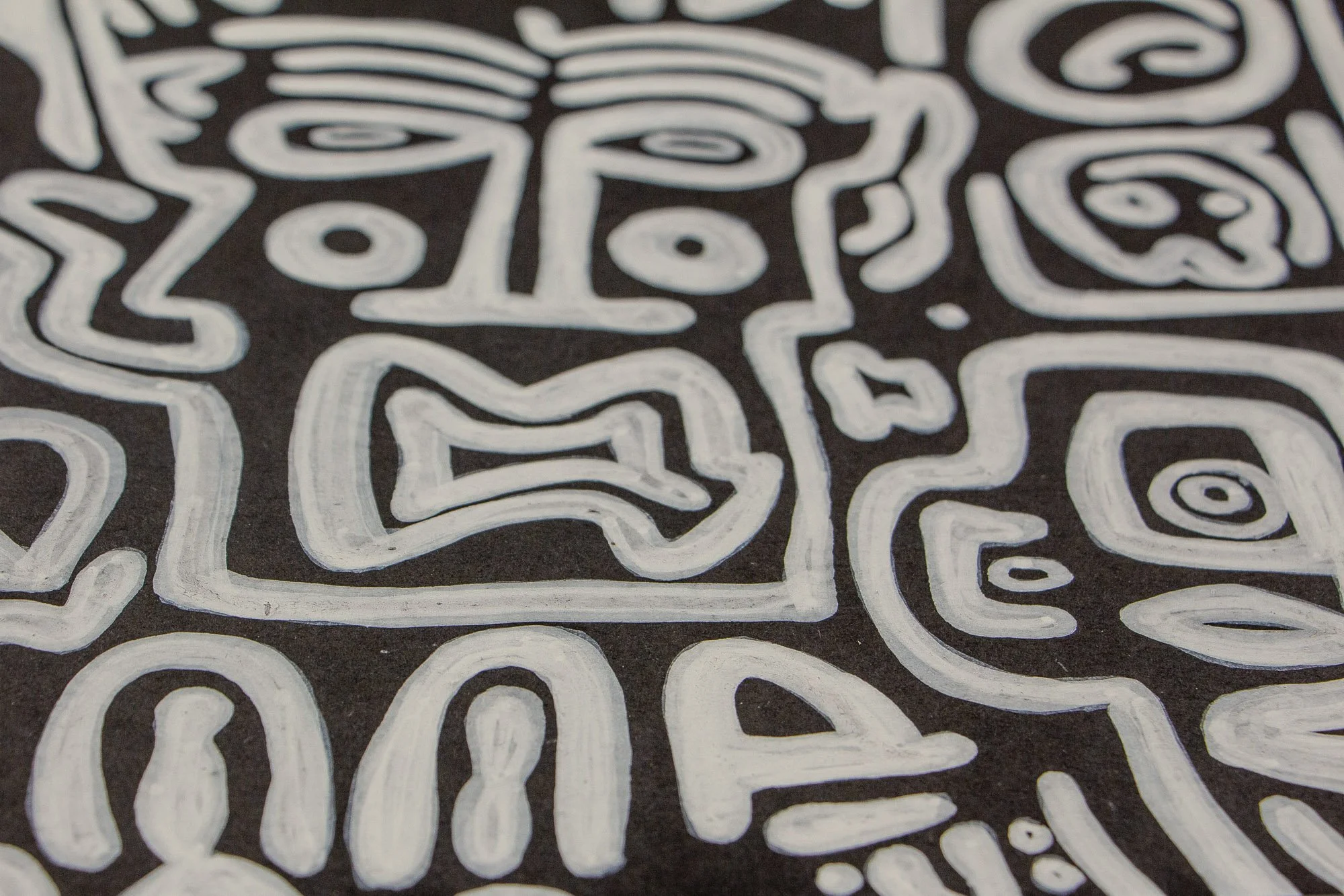 Turbulent Aegis 001 artwork detail: close-up of a central white-lined face on a dark ground, with an open mouth, spiral eyes, and surrounding glyph-like forms that suggest tension held within structure.