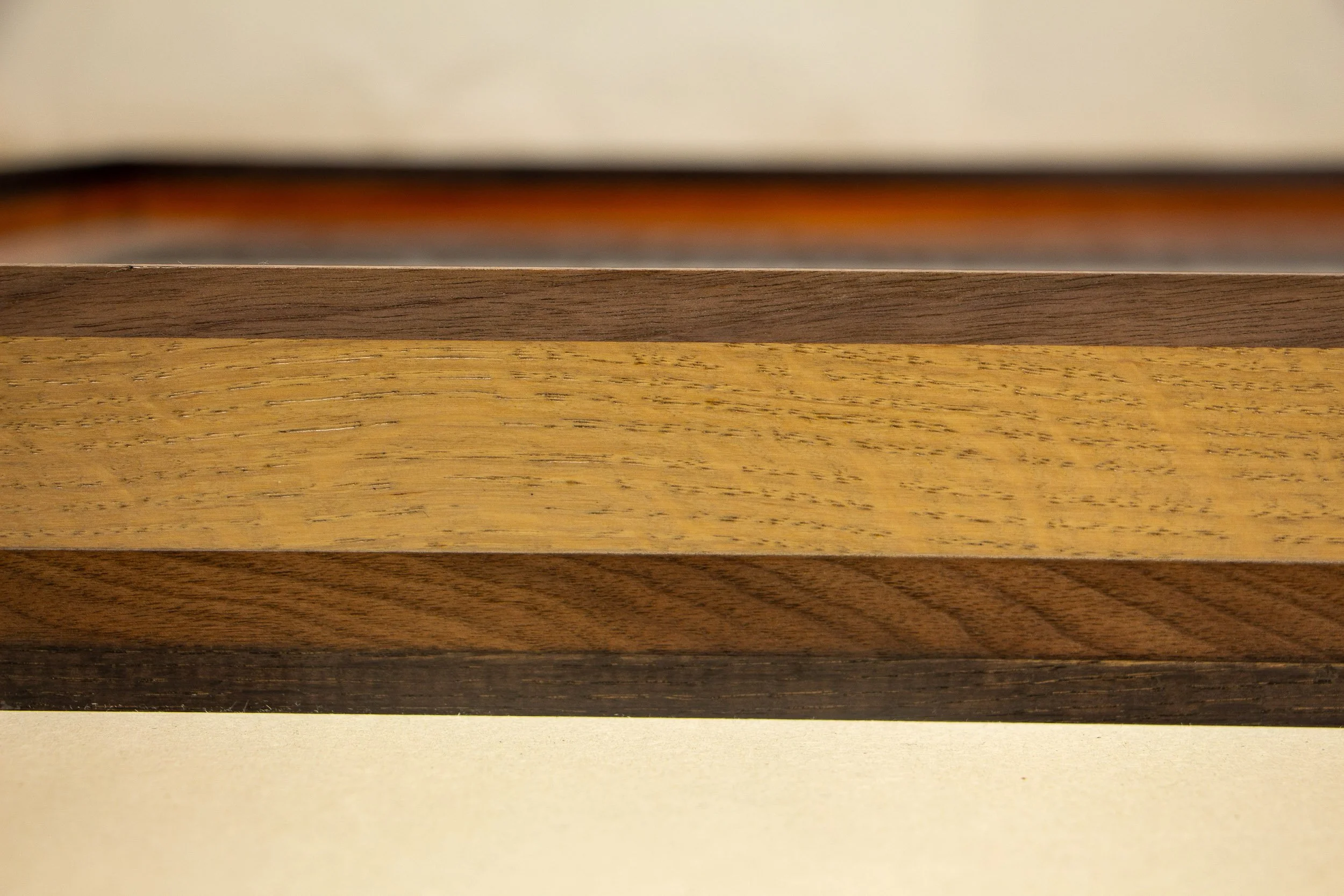 Close-up image of a wooden art frame with four types of wood, arranged horizontally.