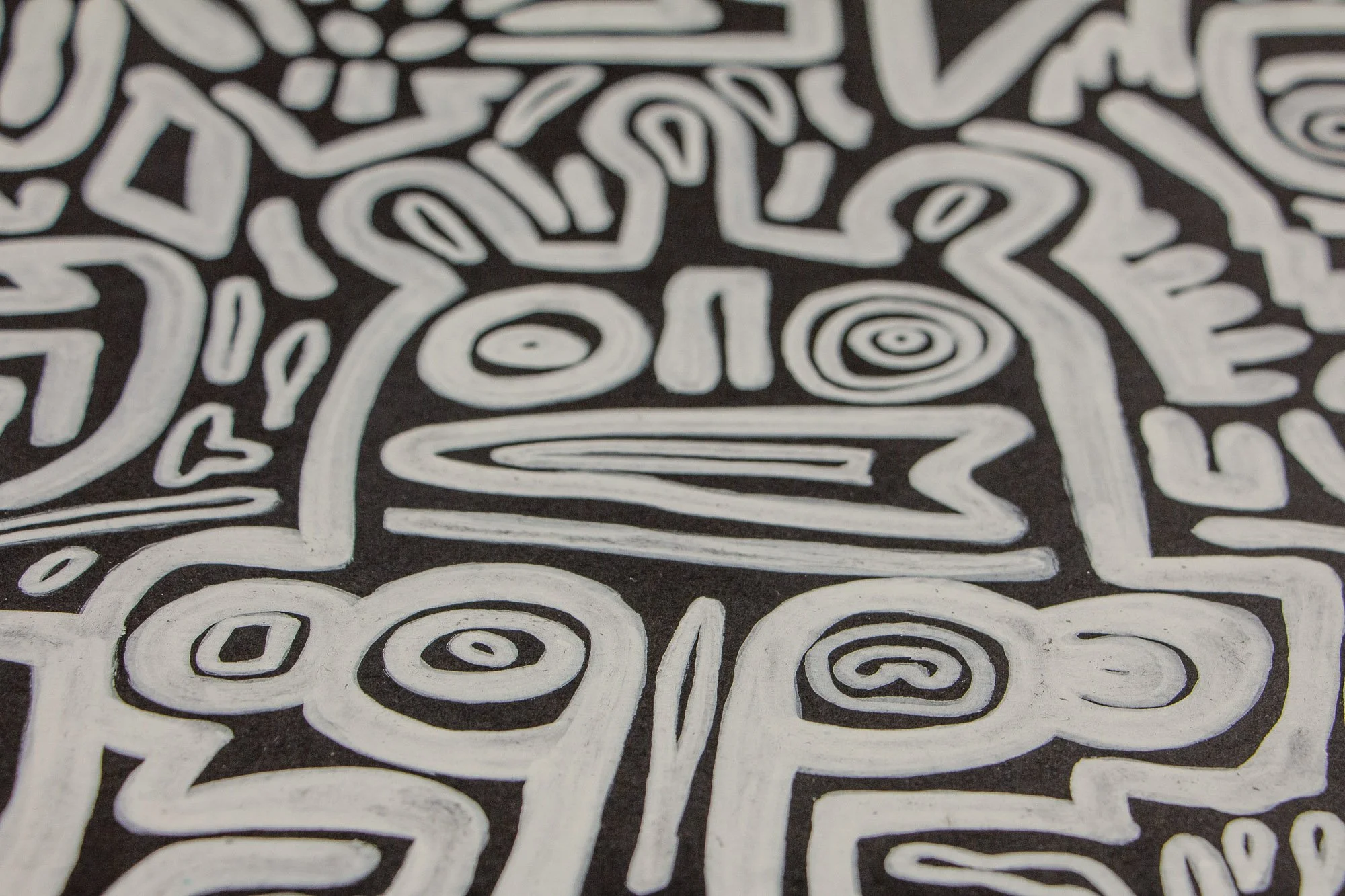 Turbulent Aegis 002 artwork detail: close-up of a central face-like figure with concentric eyes and a long horizontal mouth, held within a tightly packed field of surrounding forms.