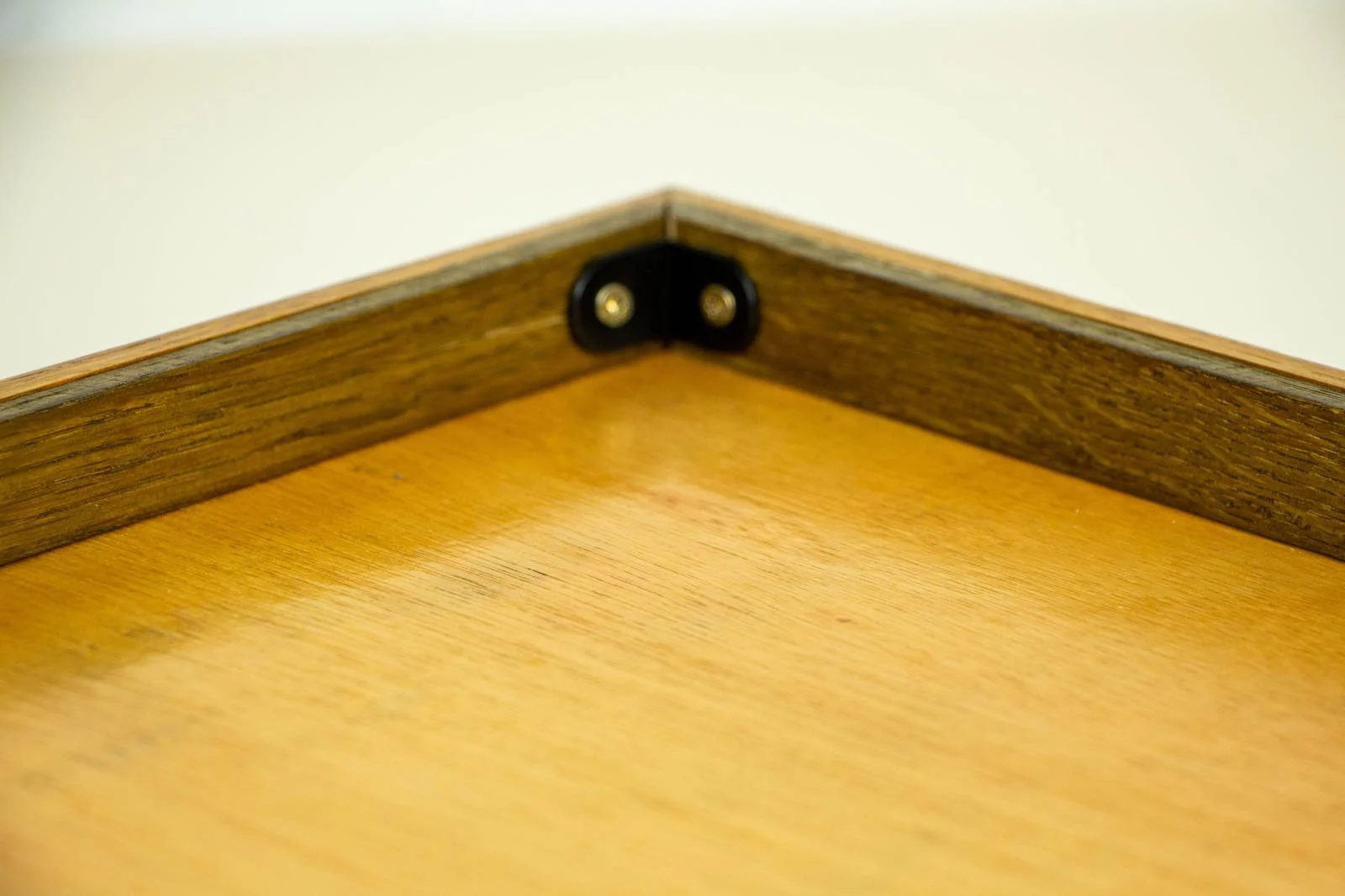 Metamorphic Entwining 002 frame: rear corner, stained spacer rail with neat black L-bracket securing the back panel