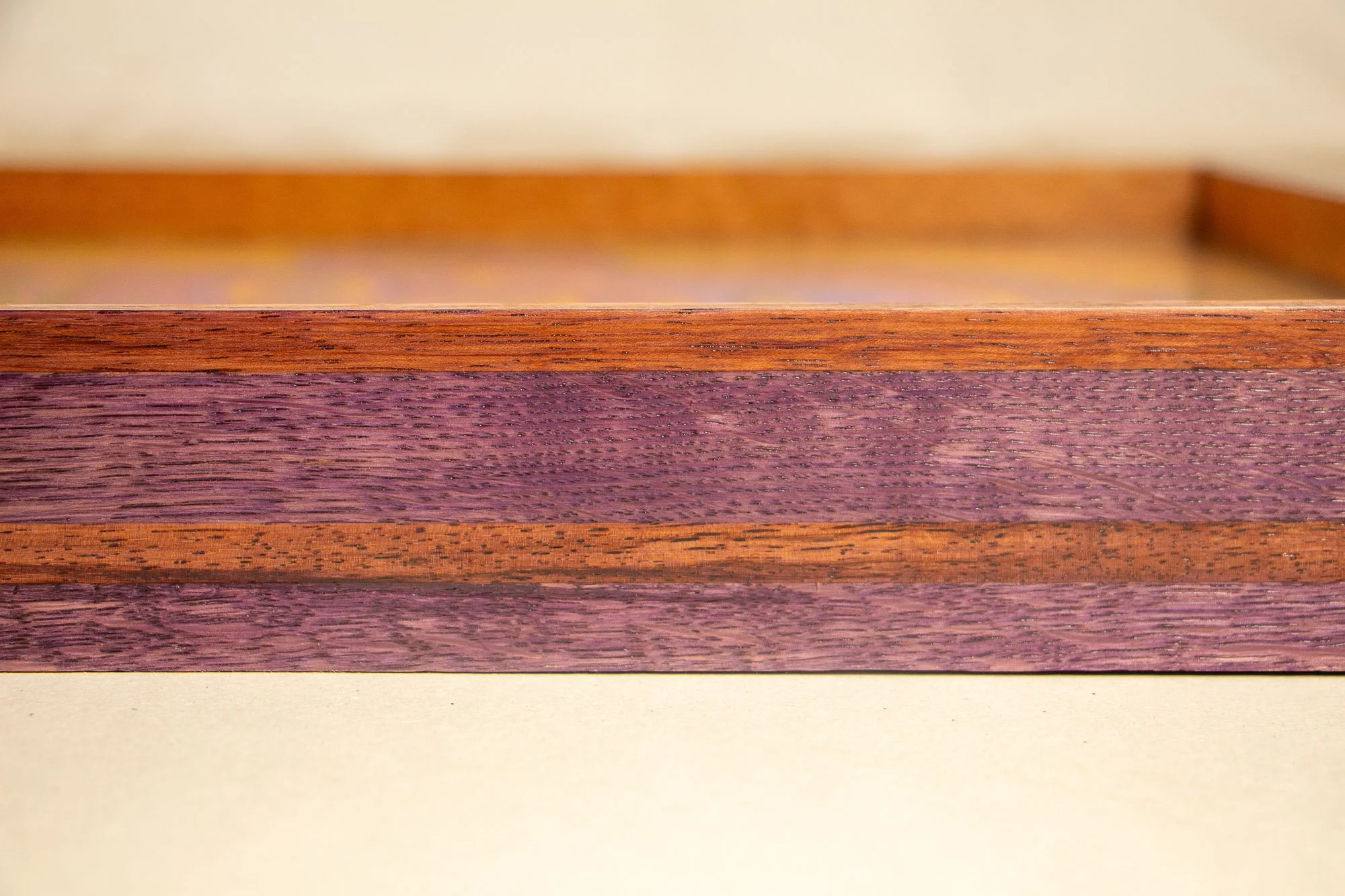  Unseen Signifiers 009 frame detail: horizontal close-up of the frame side, focusing on the grain and tonal contrast between the plum wood body and the thin brown inlay. mahogany, oak and beech wood.