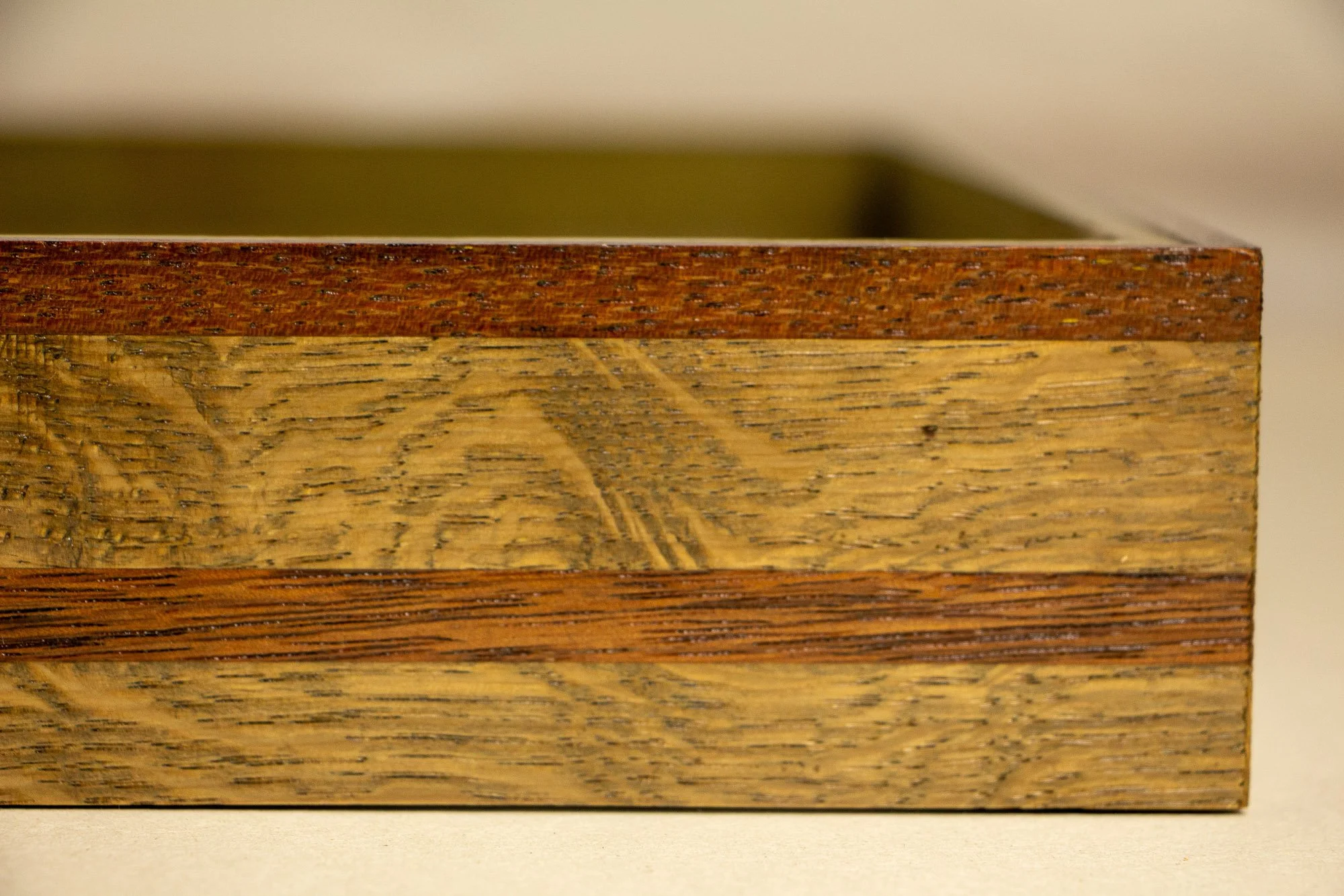 Unseen Signifiers 001 frame detail: side view of the layered wooden frame with shallow focus, showing alternating light and dark wood bands and the depth of the frame construction. mahogany, oak and beech wood.