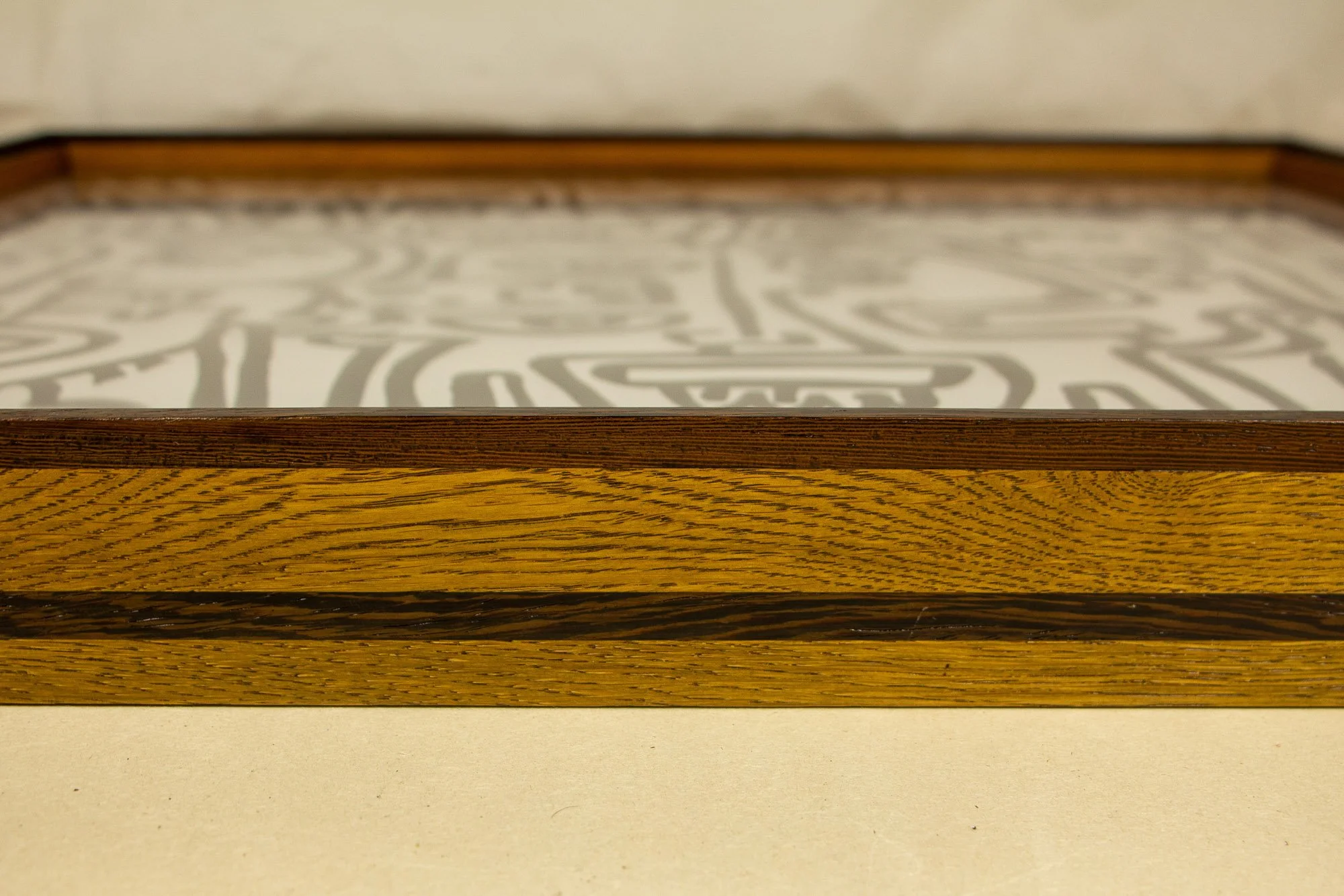 Close-up of a wooden art frame with a artwork inside visible from the top.