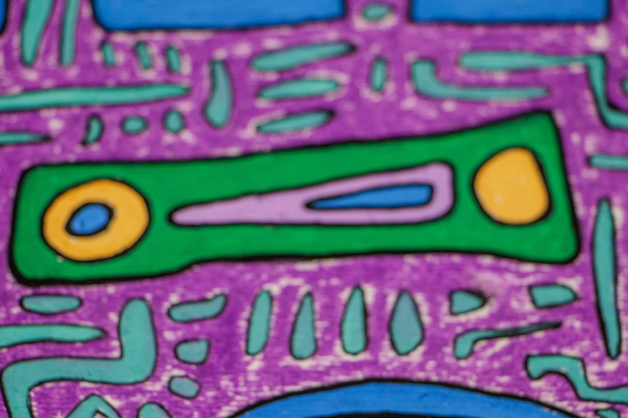 Unseen Signifiers 009 artwork detail: soft-focus close-up of the elongated green symbol near the upper center, containing lavender, blue, and gold elements against the purple ground.