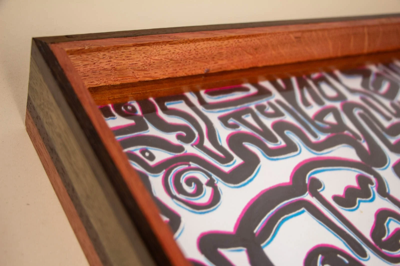 Silence’s Caesura 001 frame: oblique view, stepped rails lead the eye from the mahogany base to the pink liner; float mount sits recessed