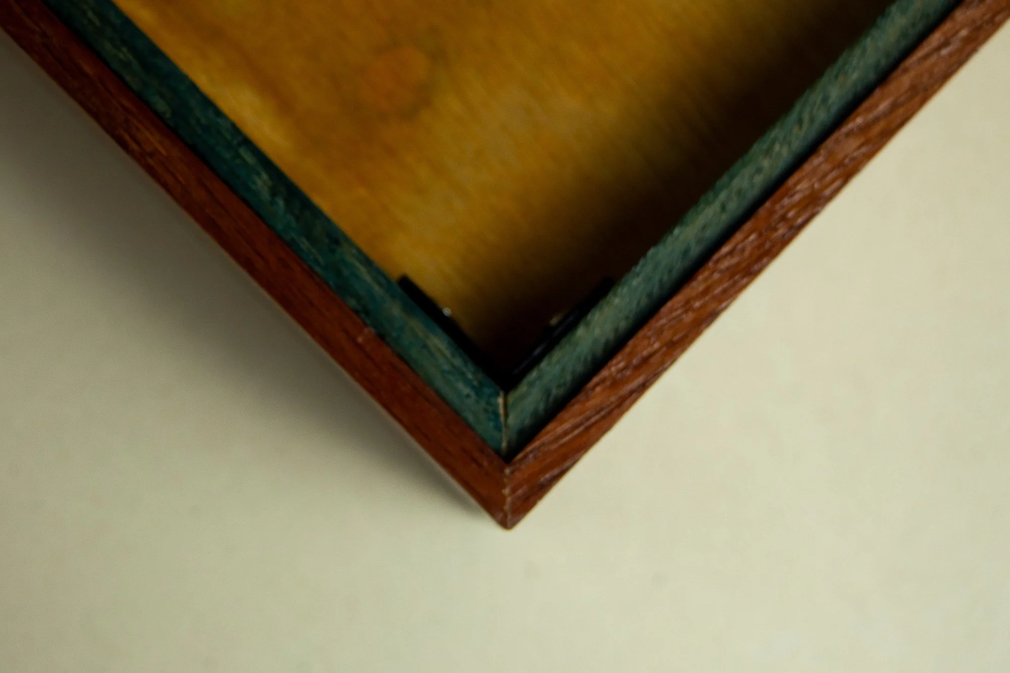 Unseen Signifiers 005 frame detail: reverse corner view of the frame, showing the warm wood back panel, olive-green inner support rim, black corner bracket, and the reddish-brown outer frame construction. mahogany, oak and beech wood.