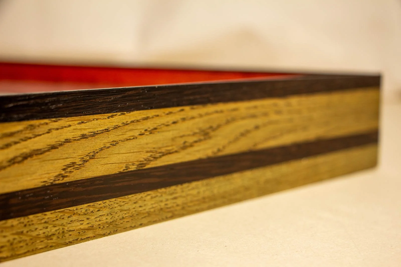 Formless Equation 002 frame: perspective along olive-tinted oak, wengé top edge, depth toward glazing