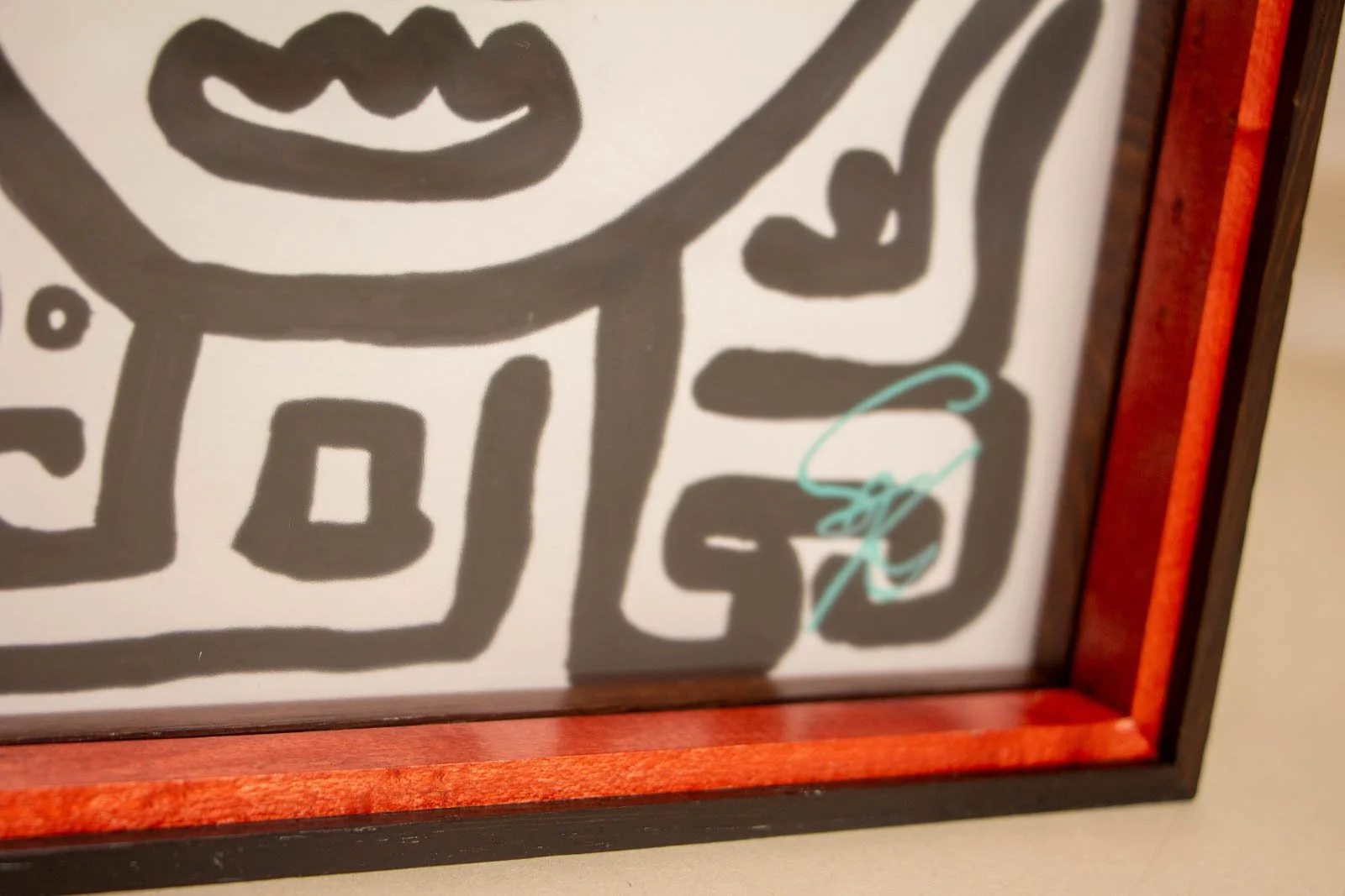 Formless Equation 002 frame: lower-right corner with artist’s teal signature, red spacer, wengé inner lip