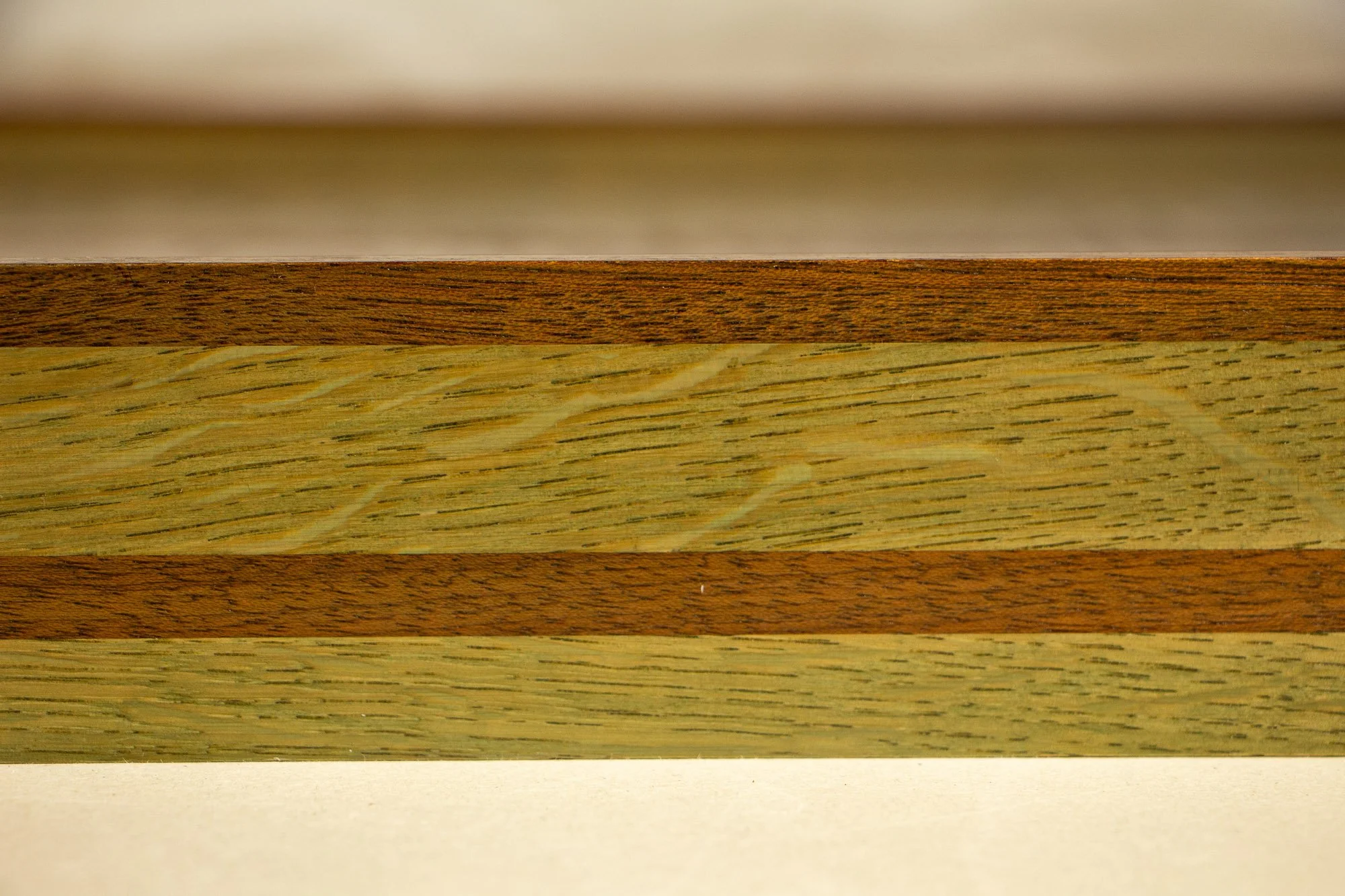 Resonant Syntax 002 frame: frontal detail of the laminated frame, with layered colored oak and mahogany bands arranged in a mint, blue, and pink sequence