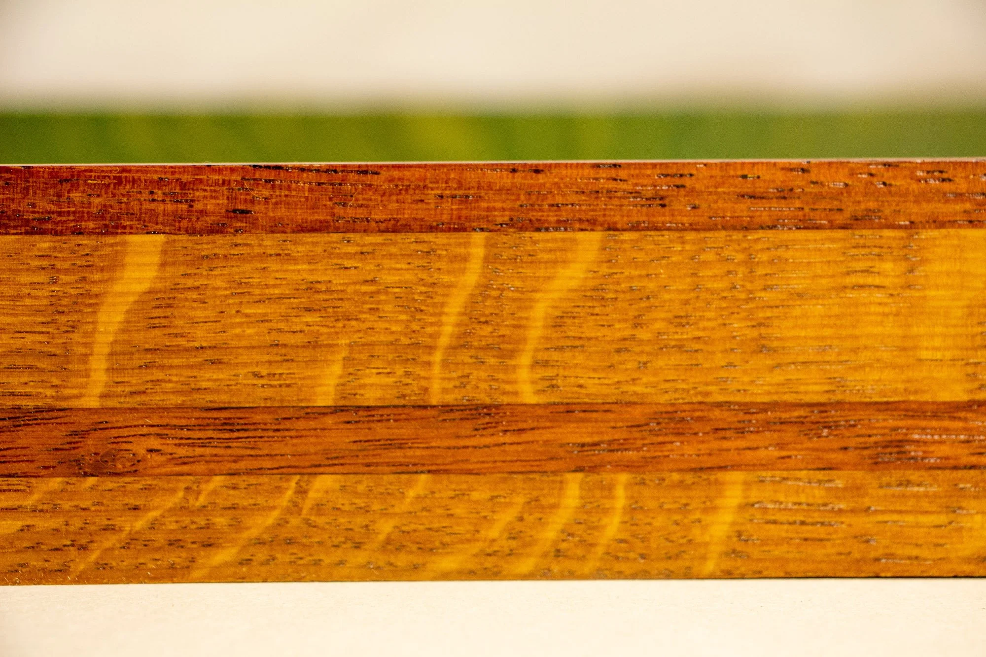 Unseen Signifiers 002 frame detail: horizontal close-up of the frame profile, showing alternating warm wood bands and visible grain running across the front edge. mahogany, oak and beech wood.