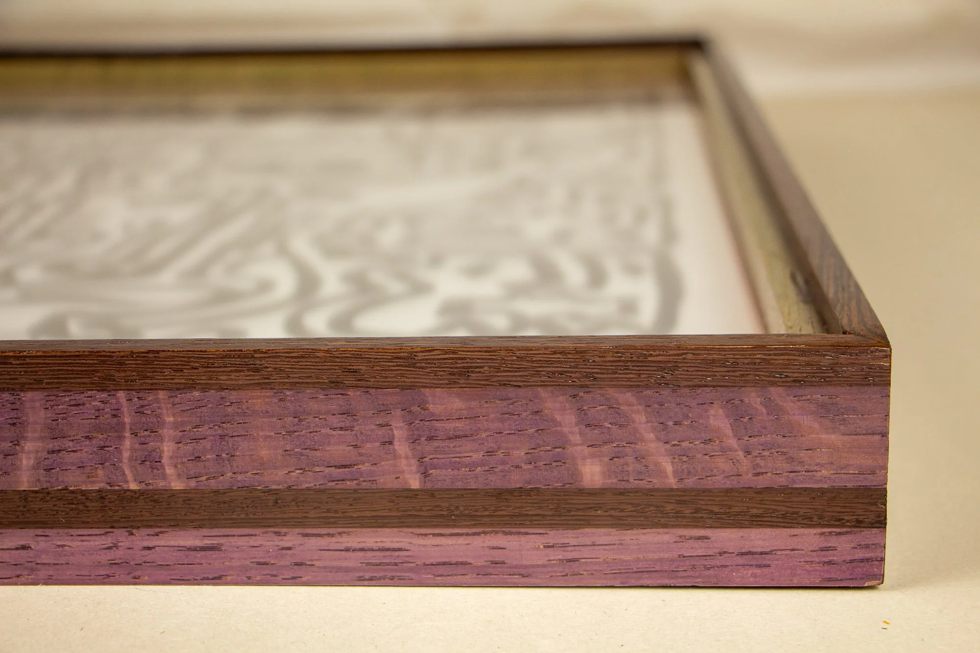 Elusive Cocoon 003 detail: close-up of a dense central cluster of face-like abstract forms with almond eyes, a mask-like vertical figure, curling contours, and interlocking black linework on warm white paper.