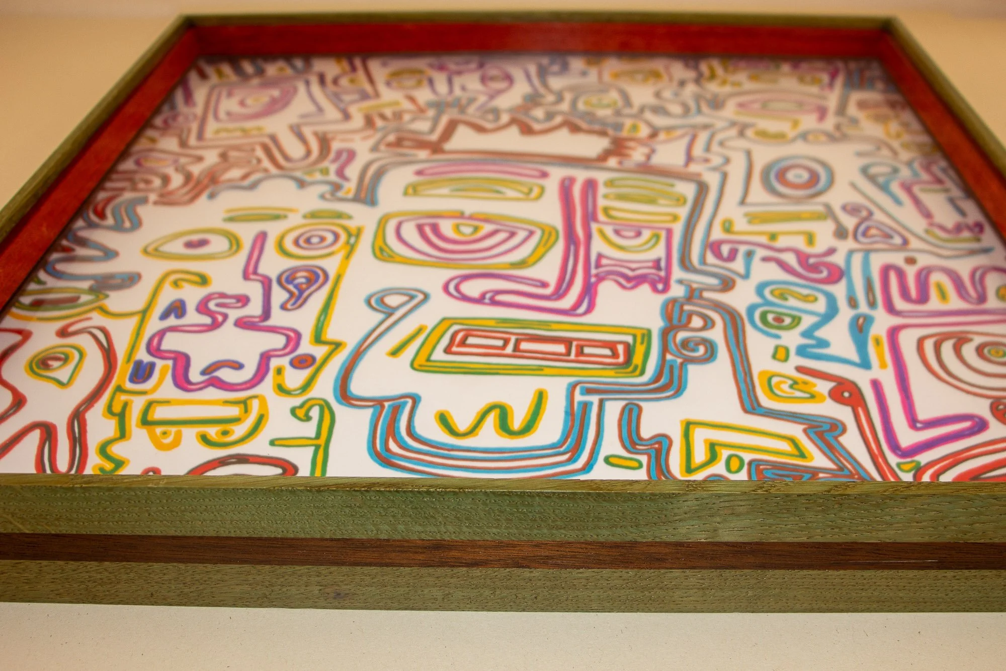 Colorful abstract artwork with various shapes and lines inside a wooden frame.