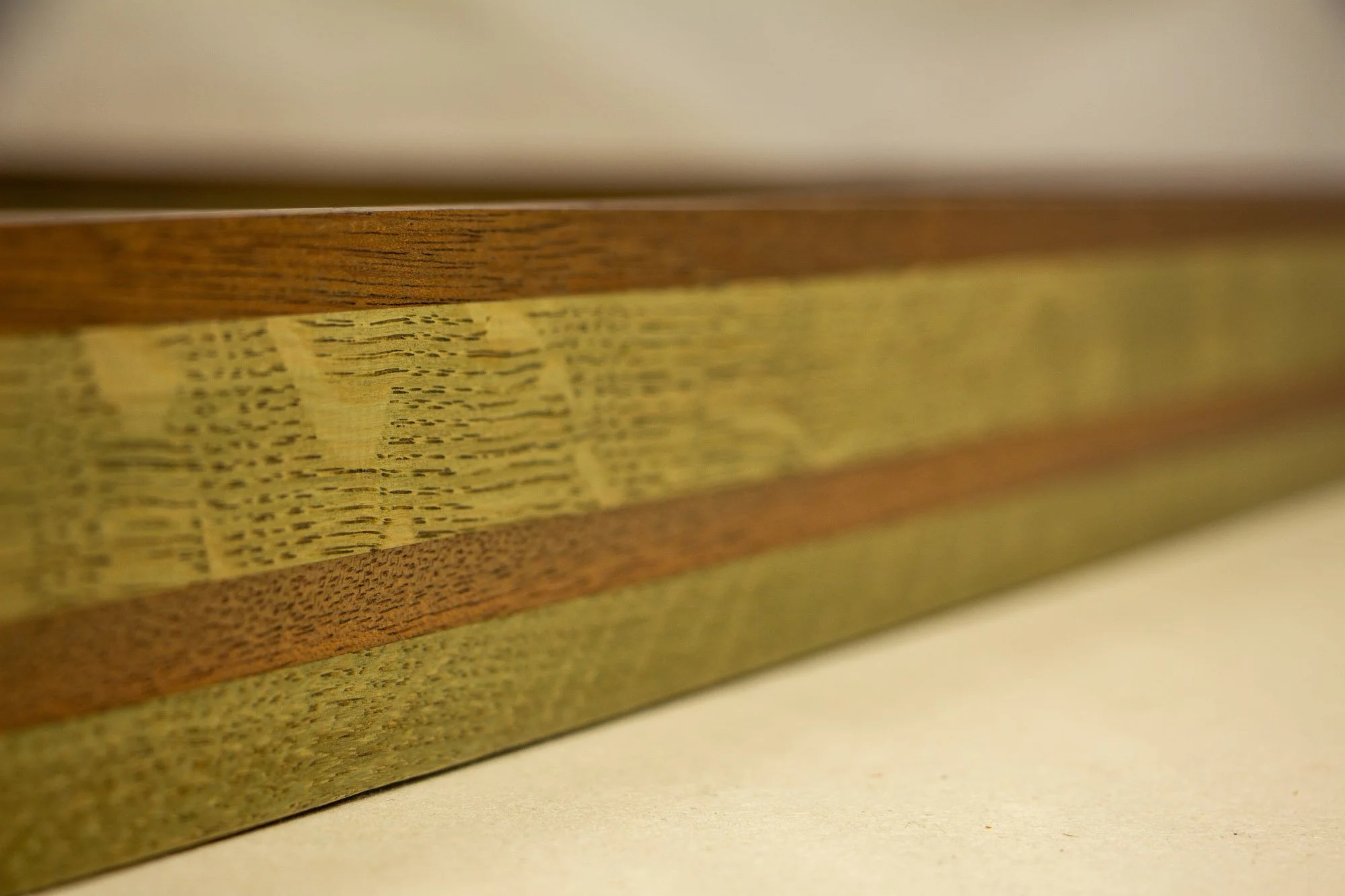 Resonant Syntax 002 frame: angled side view of the layered frame construction, emphasizing the elongated profile, tonal variation, and the contrast between mahogany and oak