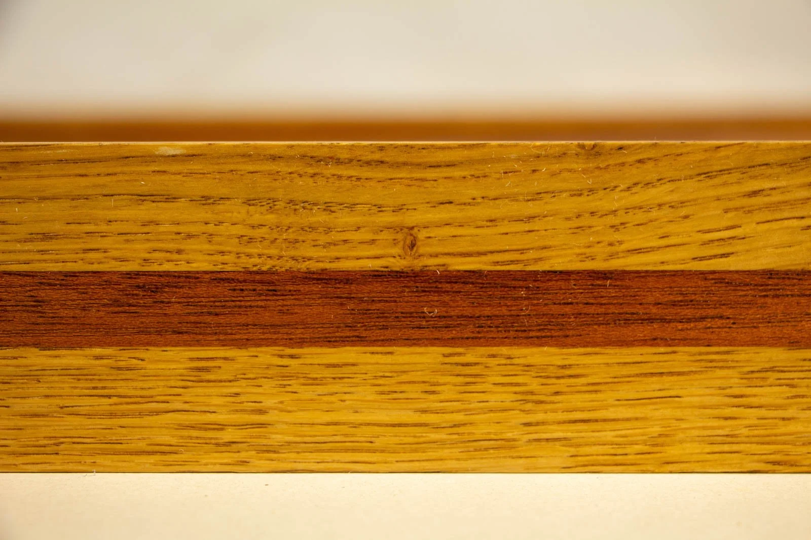 Golden Nostalgia 002 frame: close crop, contrast between golden oak grain and reddish mahogany inlay