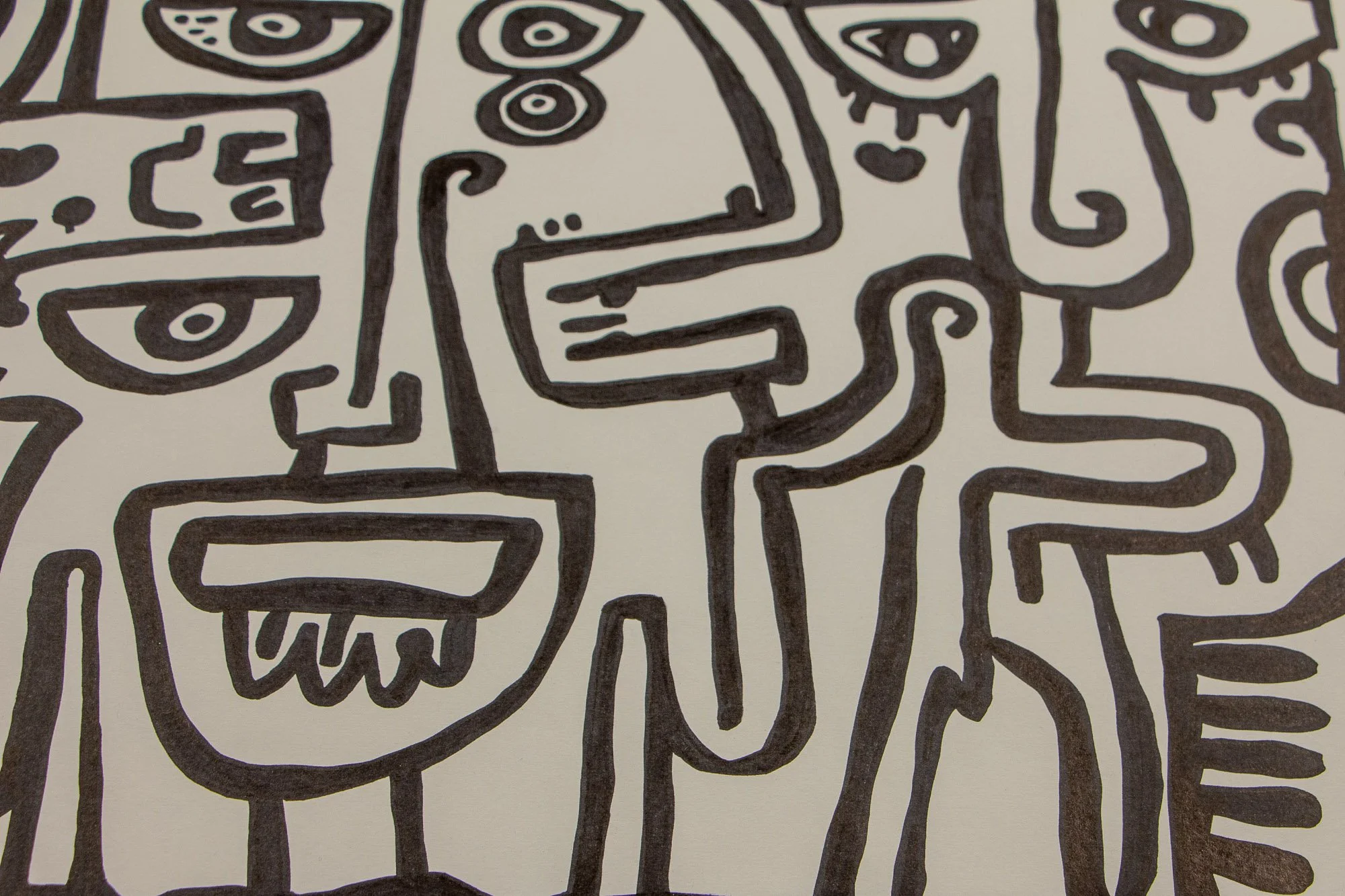 Elusive Cocoon 002 detail: close-up of two adjoining profile-like figures with spiral cheeks, stacked circular and almond-shaped eyes, and block-like mouths drawn in bold black marker.